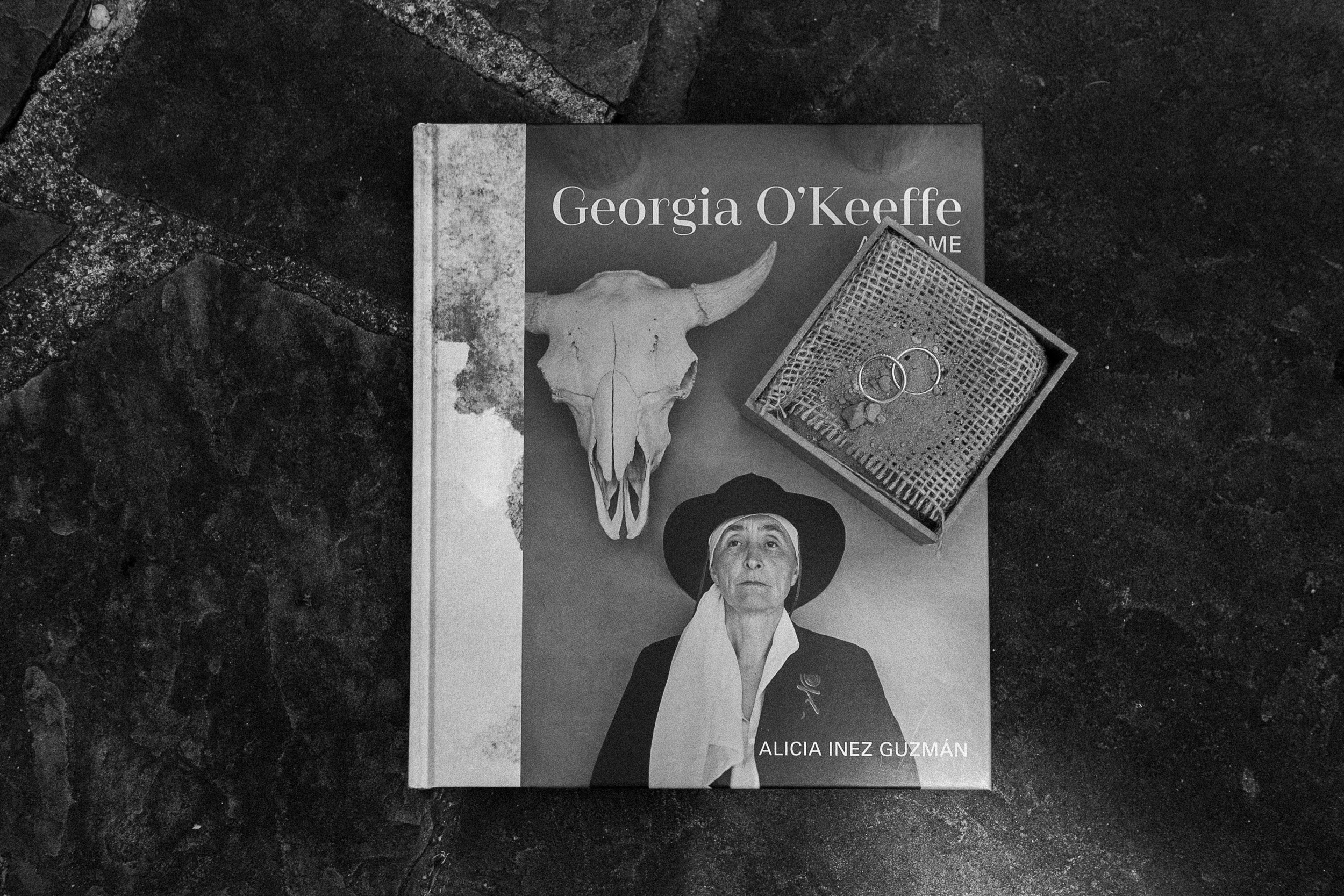 Black and white photo of Georgia O’Keefe book and wedding rings at Inn of the Turquoise Bear | Santa Fe lesbian elopement | Santa Fe elopement photographer | Santa Fe wedding | LGBTQ elopement | Photo by Denver Elopement Photographer Ashley Joyce Photography, copyright 2021 