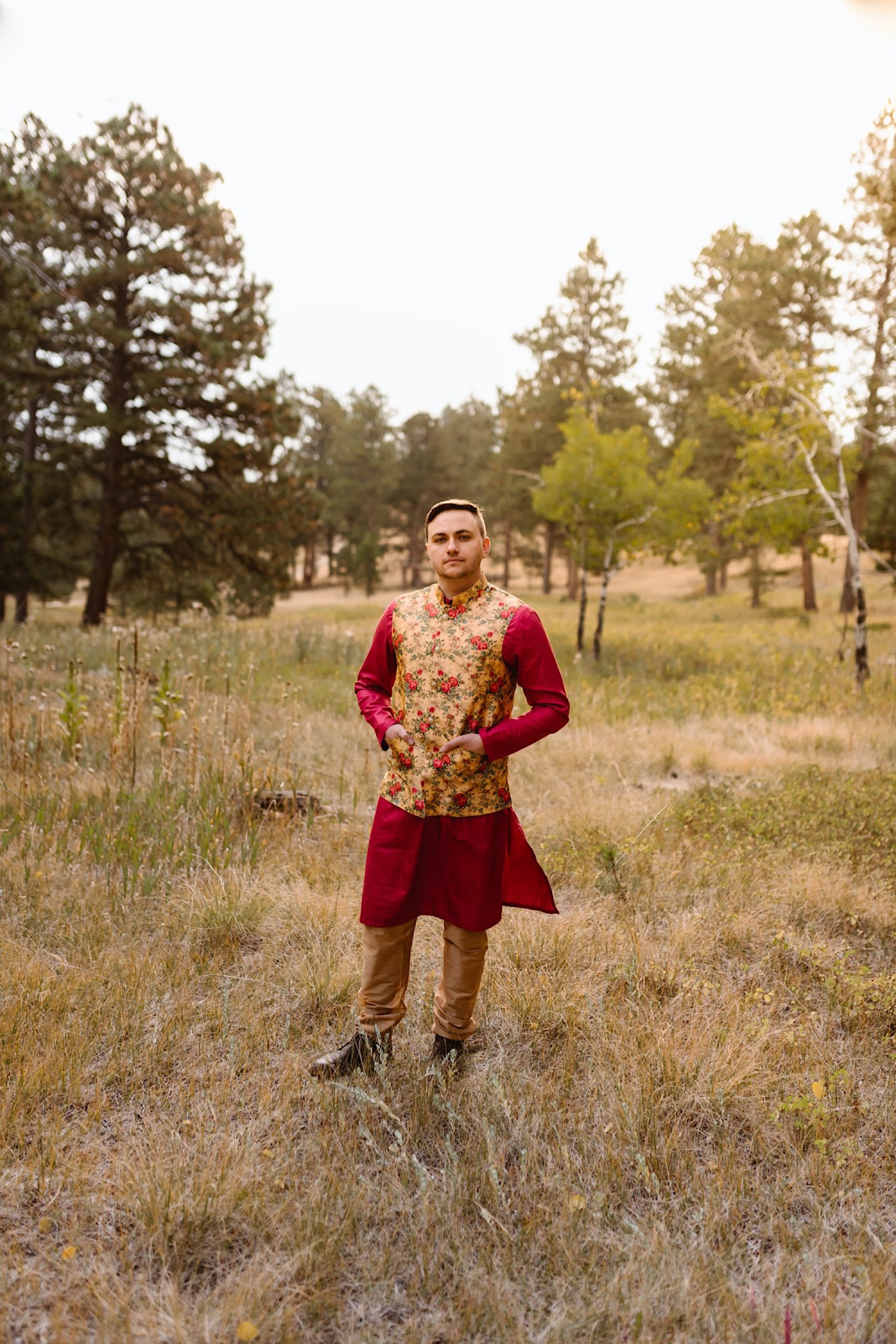 A Colorado Indian groom stands in his traditional Indian wedding attire for his elopement photos. The groom looks towards the camera as he poses for his Denver elopement photos. Photo by Denver elopement photographer, Colorado elopement photographer, Ashley Joyce Photography.
