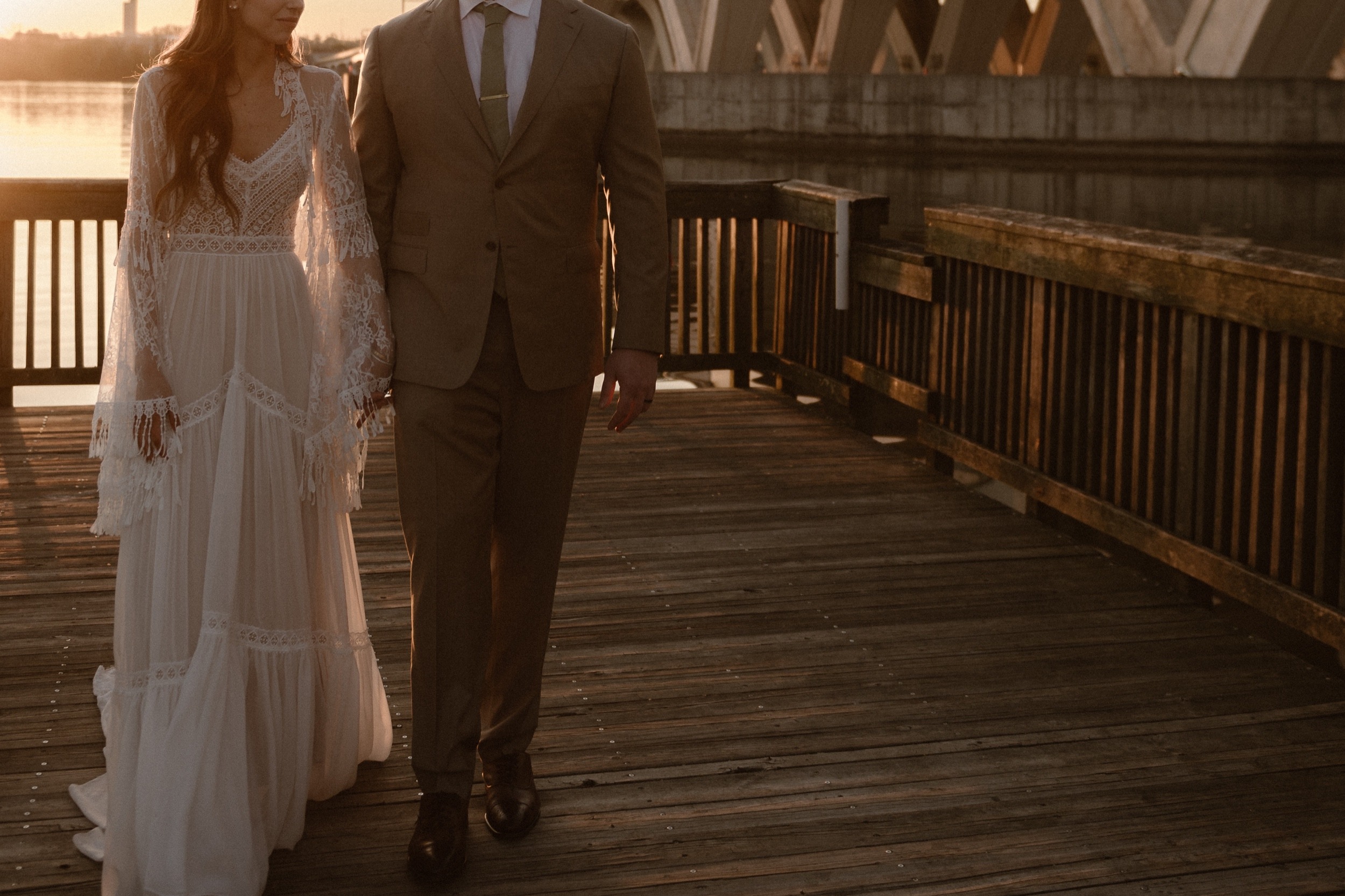 A married couple poses for their Alexandria, Virginia wedding anniversary photo session at Jones Point Park with Colorado photographer, Ashley Joyce Photography. Copyright Ashley Joyce Photography 2022.