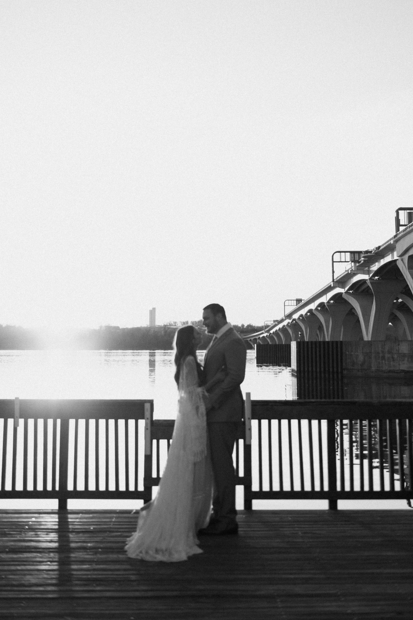 A married couple poses for their Alexandria, Virginia wedding anniversary photo session at Jones Point Park with Colorado photographer, Ashley Joyce Photography. Copyright Ashley Joyce Photography 2022.