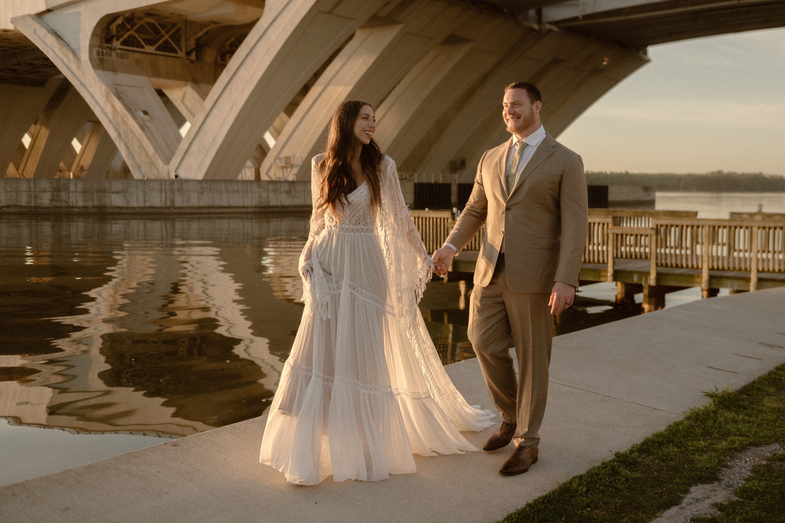 A married couple poses for their Alexandria, Virginia wedding anniversary photo session at Jones Point Park with Colorado photographer, Ashley Joyce Photography. Copyright Ashley Joyce Photography 2022.