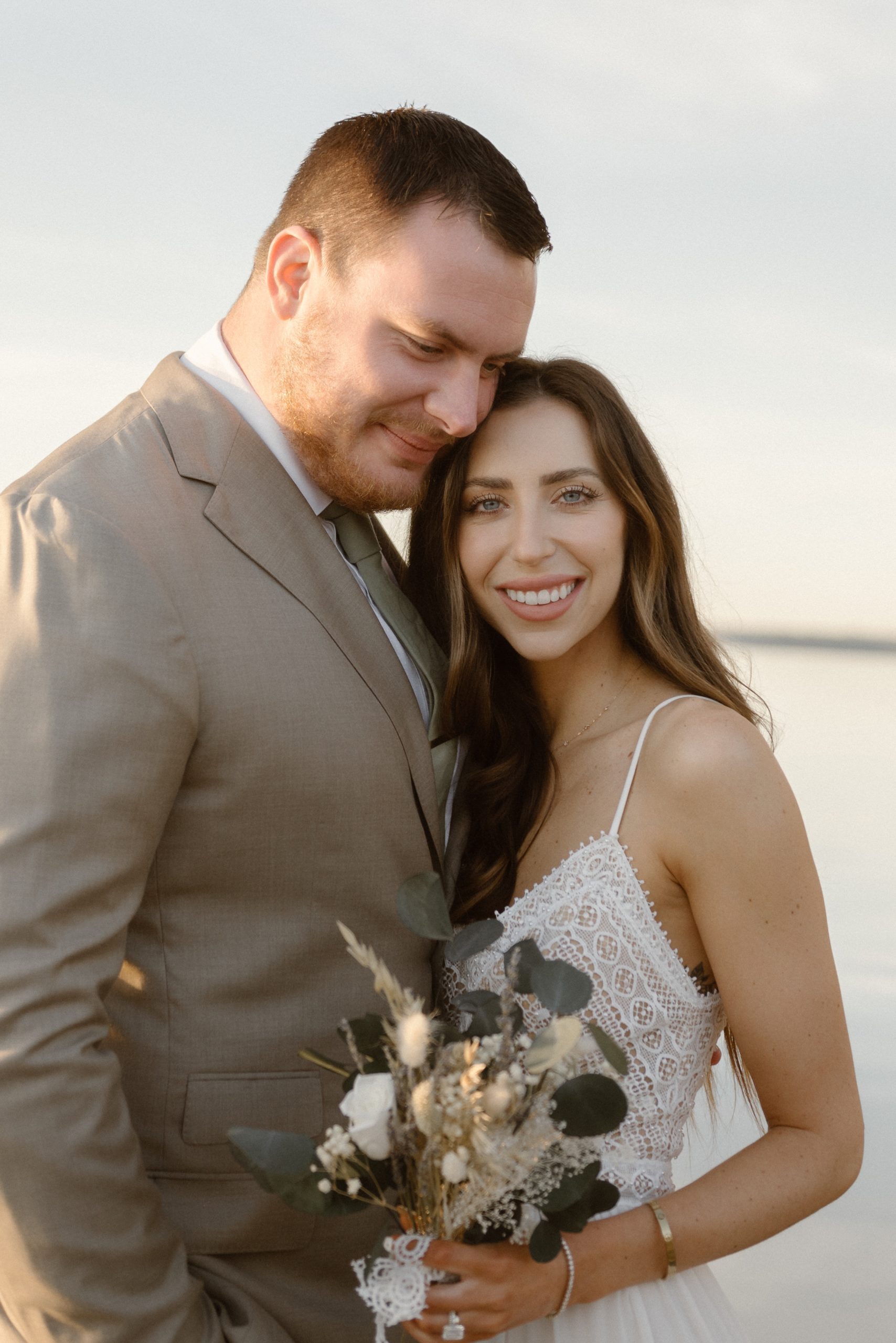 A married couple poses for their Alexandria, Virginia wedding anniversary photo session at Jones Point Park with Colorado photographer, Ashley Joyce Photography. Copyright Ashley Joyce Photography 2022.