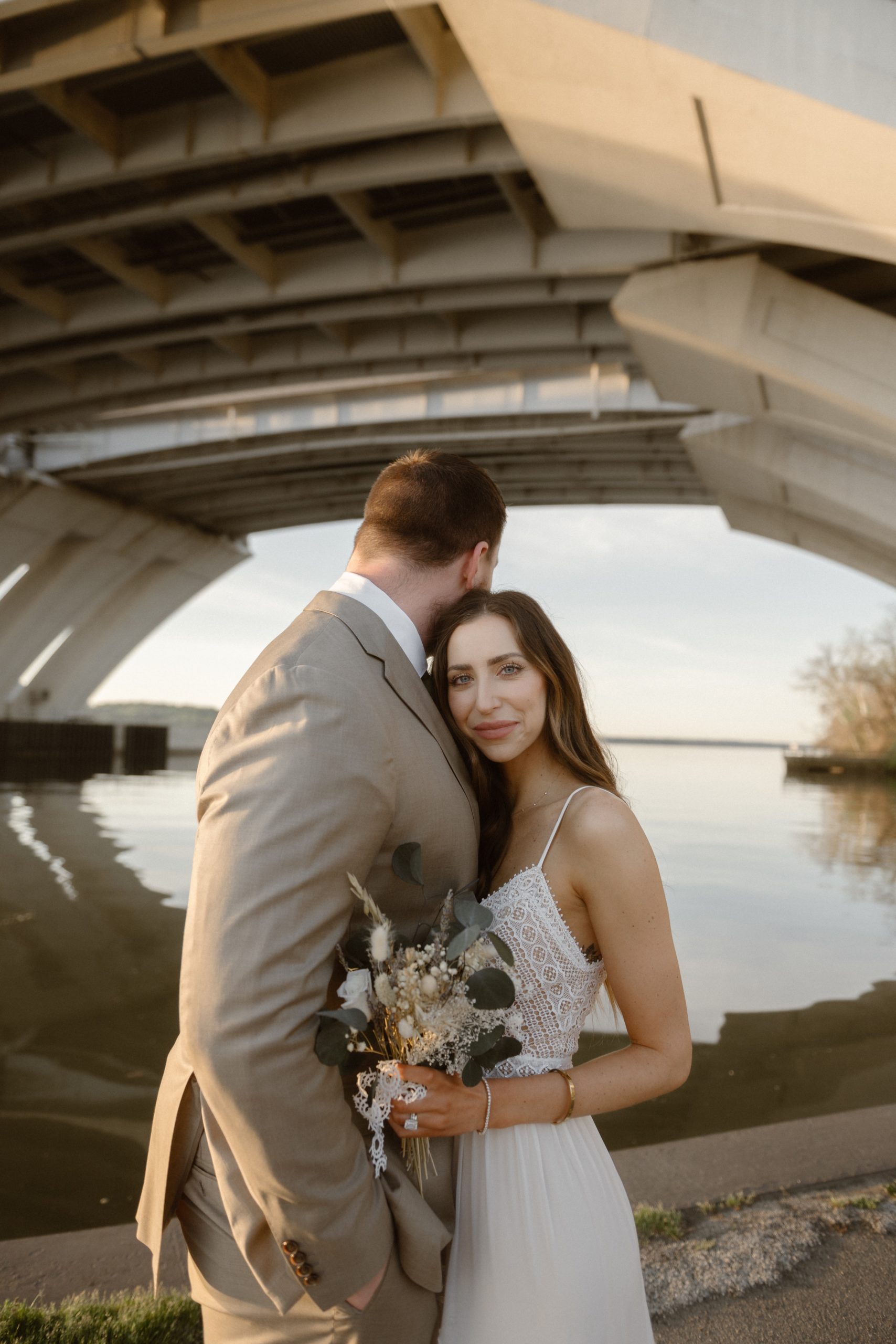 A married couple poses for their Alexandria, Virginia wedding anniversary photo session at Jones Point Park with Colorado photographer, Ashley Joyce Photography. Copyright Ashley Joyce Photography 2022.