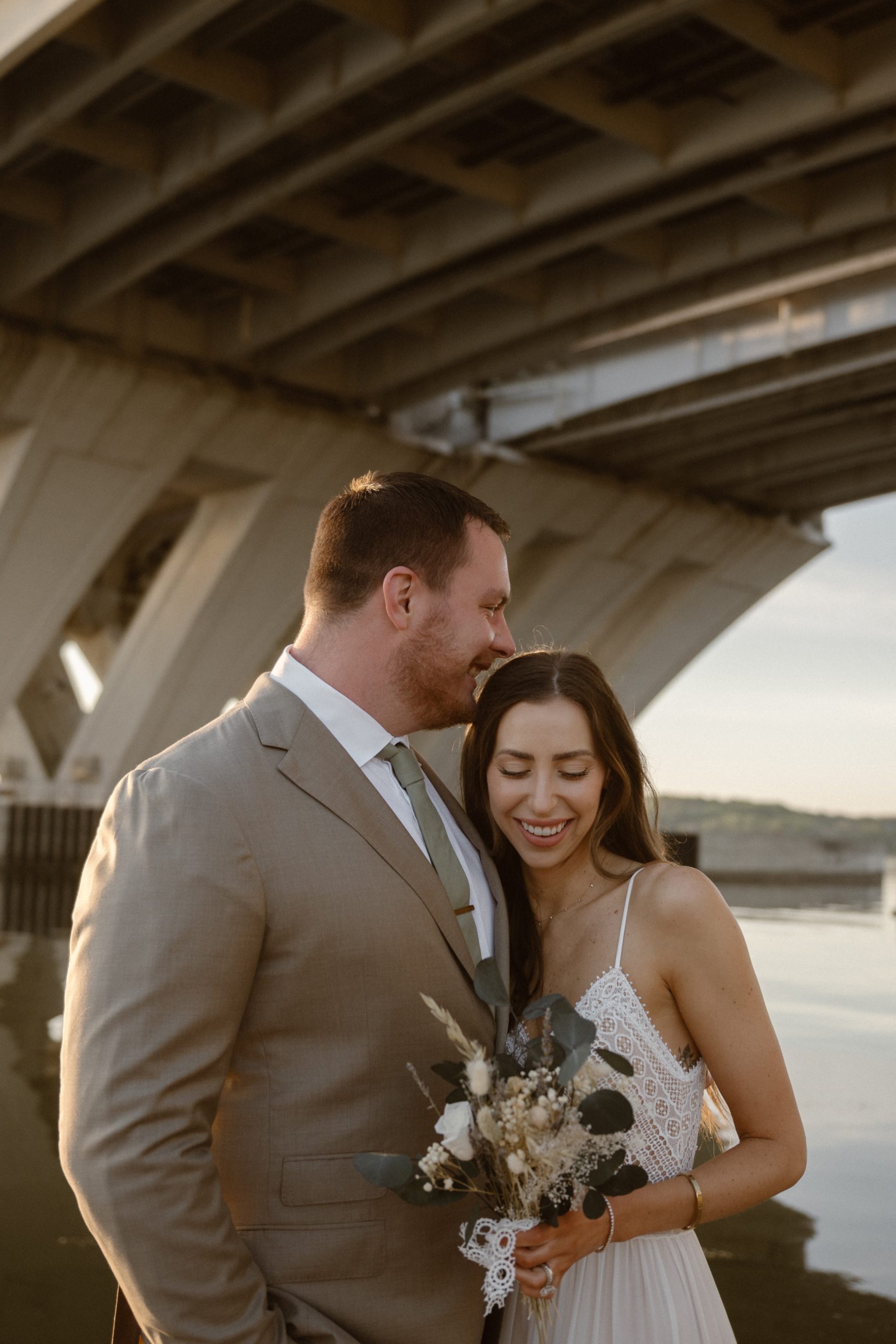 A married couple poses for their Alexandria, Virginia wedding anniversary photo session at Jones Point Park with Colorado photographer, Ashley Joyce Photography. Copyright Ashley Joyce Photography 2022.