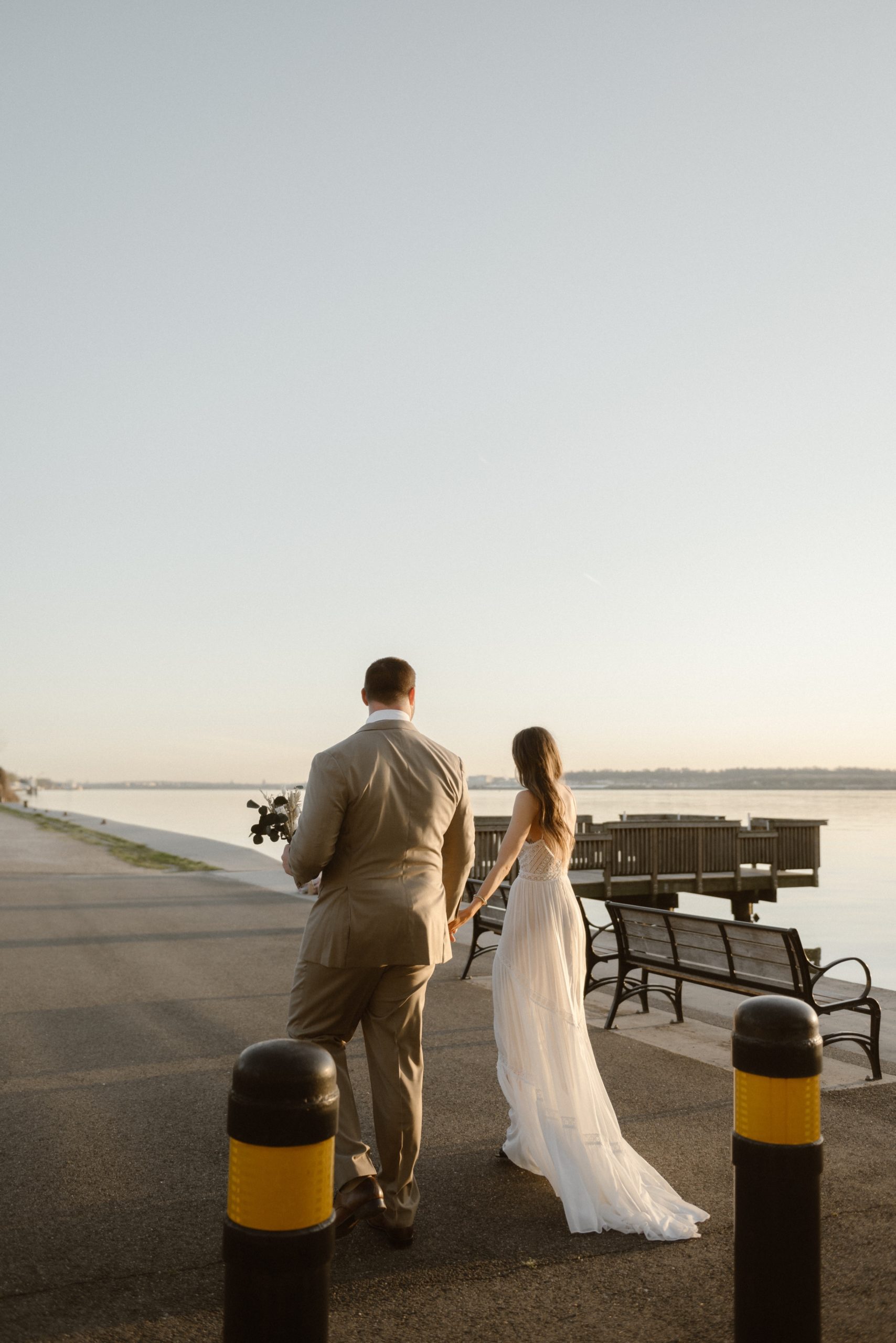 A married couple poses for their Alexandria, Virginia wedding anniversary photo session at Jones Point Park with Colorado photographer, Ashley Joyce Photography. Copyright Ashley Joyce Photography 2022.