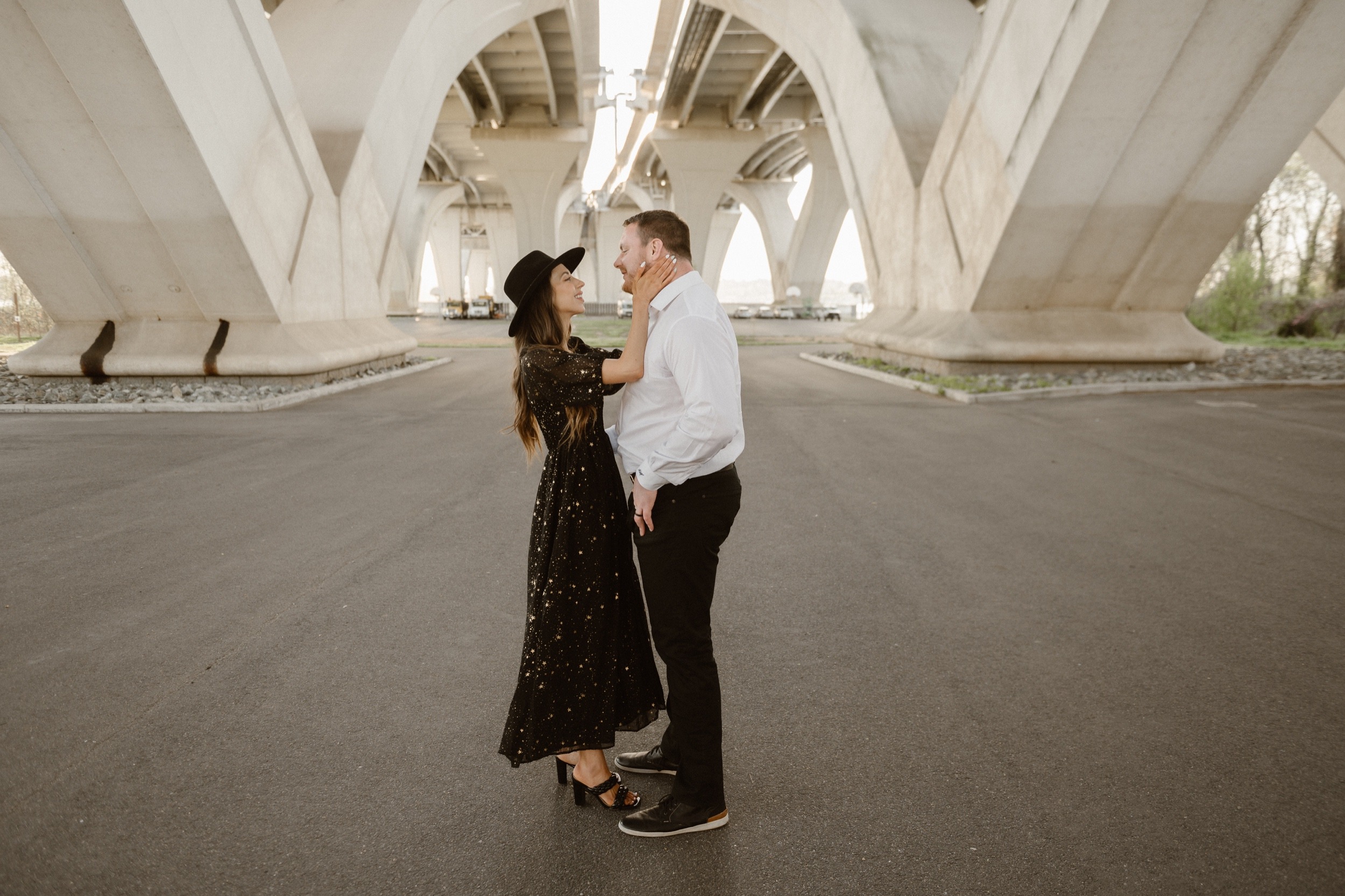 A married couple poses for their Alexandria, Virginia wedding anniversary photo session at Jones Point Park with Colorado photographer, Ashley Joyce Photography. Copyright Ashley Joyce Photography 2022.