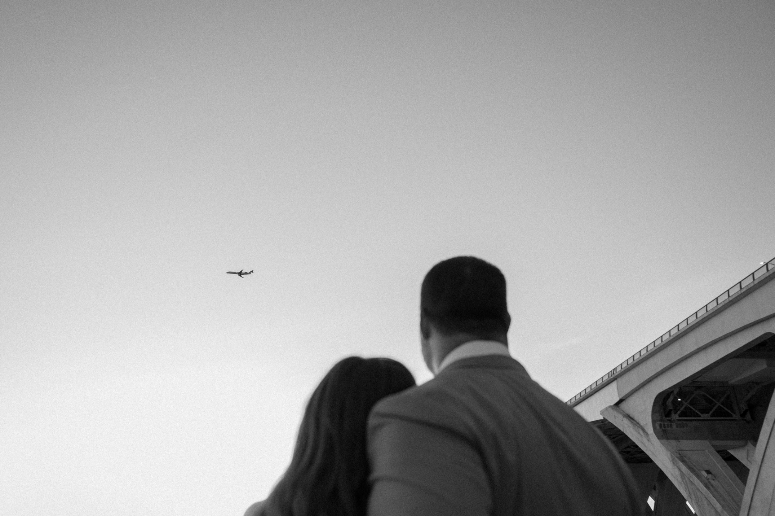 A married couple poses for their Alexandria, Virginia wedding anniversary photo session at Jones Point Park with Colorado photographer, Ashley Joyce Photography. Copyright Ashley Joyce Photography 2022.