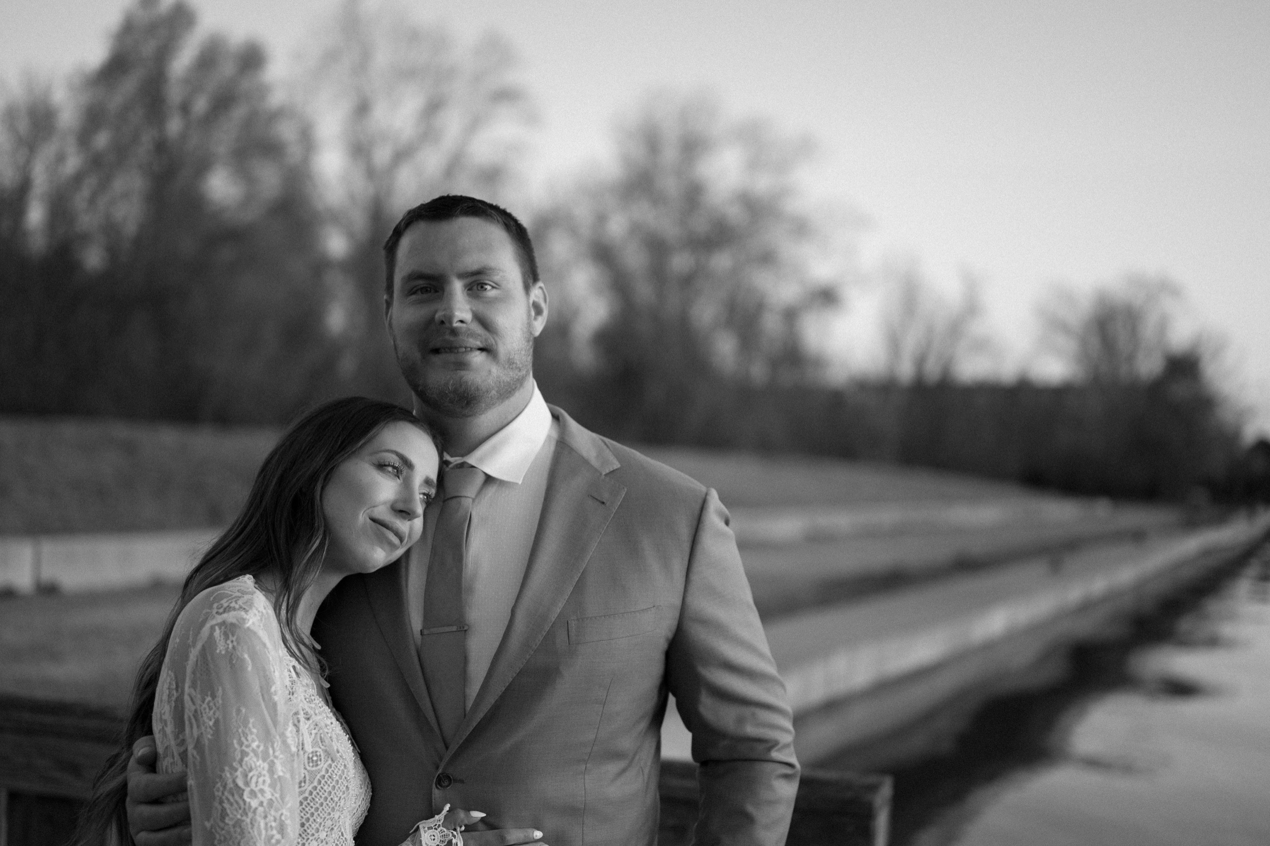 A married couple poses for their Alexandria, Virginia wedding anniversary photo session at Jones Point Park with Colorado photographer, Ashley Joyce Photography. Copyright Ashley Joyce Photography 2022.