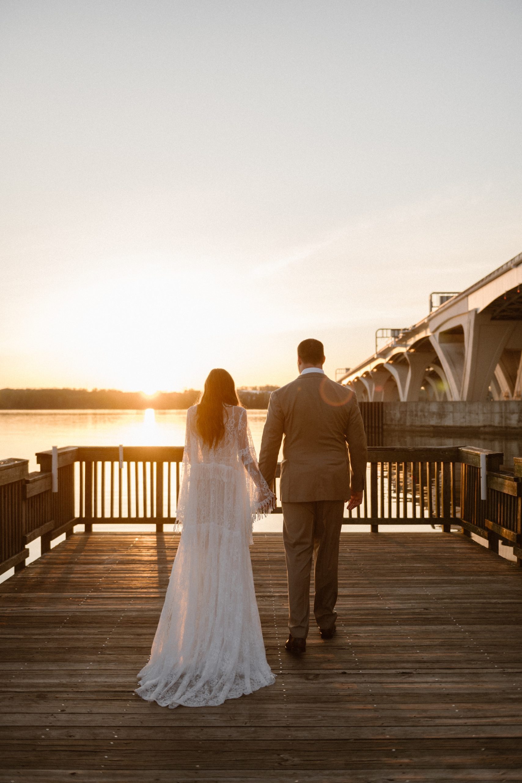 A married couple poses for their Alexandria, Virginia wedding anniversary photo session at Jones Point Park with Colorado photographer, Ashley Joyce Photography. Copyright Ashley Joyce Photography 2022.