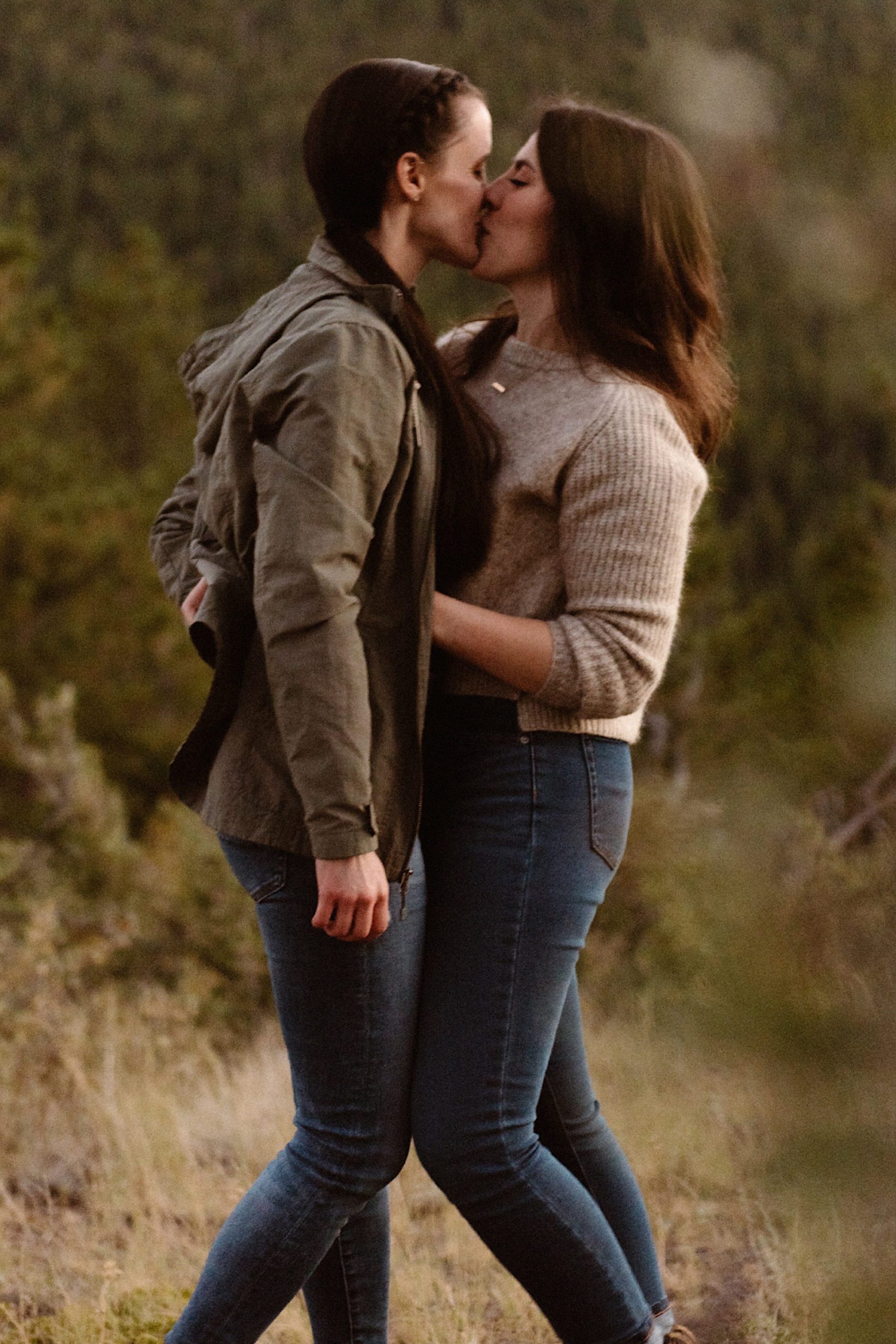 A lesbian engagement couple cuddles together at Golden Gate Canyon State Park for their Colorado engagement photos. Lesbian engagement photos | LGBTQ engagement photos in Denver | Denver engagement photos | Boulder engagement photos | Colorado engagement photos | LGBTQ Colorado engagement | Photo by Colorado elopement photographer, Denver elopement photographer, Ashley Joyce Photography.