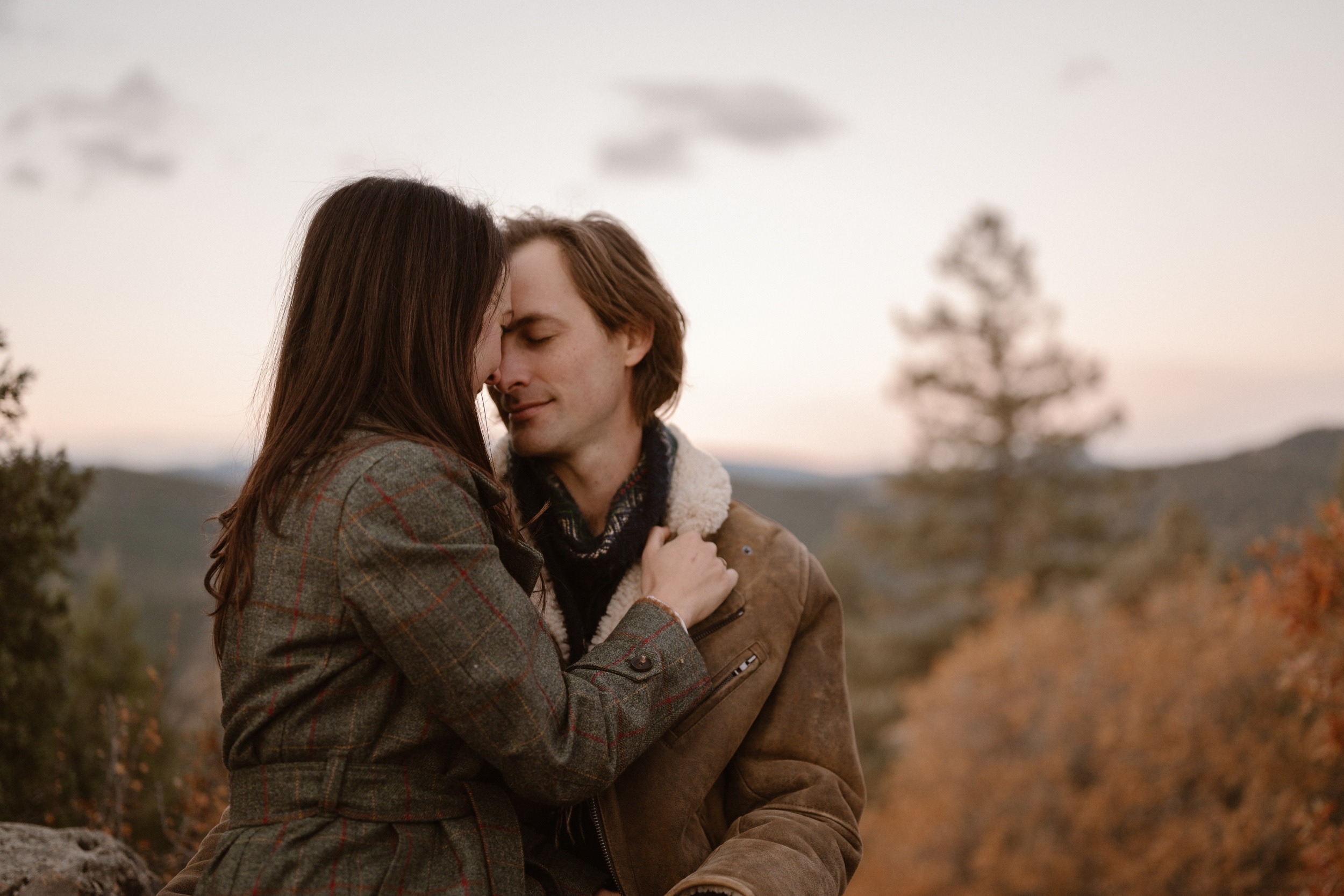 An engaged couple poses at sunrise for their Colorado Fall Mount Falcon Engagement Session. Photo by Denver Engagement photographer, Ashley Joyce Photography, copyright 2022.