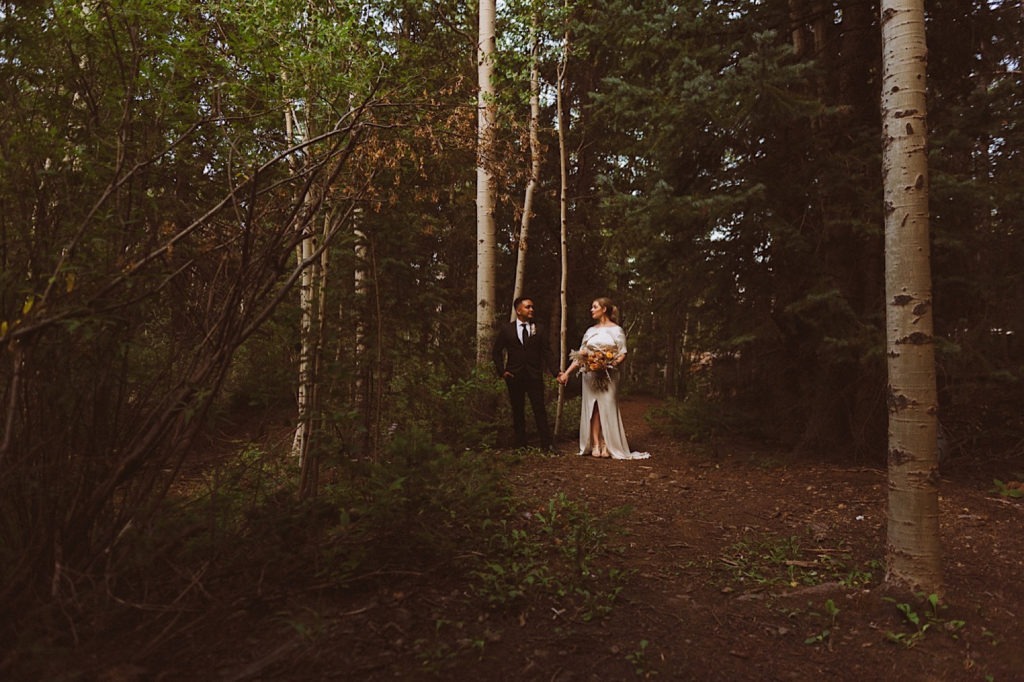 Bride and groom standing in the forest together in Colorado | Wedding portraits | Elopement portraits | Bride and groom elopement photos | Elopement wedding photos in Colorado | Colorado wedding photos | Colorado elopement photos | Elopement at Treehaus, Colorado | Treehaus Colorado | Colorado elopement | Treehaus elopement | Colorado elopement venue | Colorado mountain elopement venue | Unique elopement venue | Elopement venue in Colorado | Ashley Joyce Photography 2020