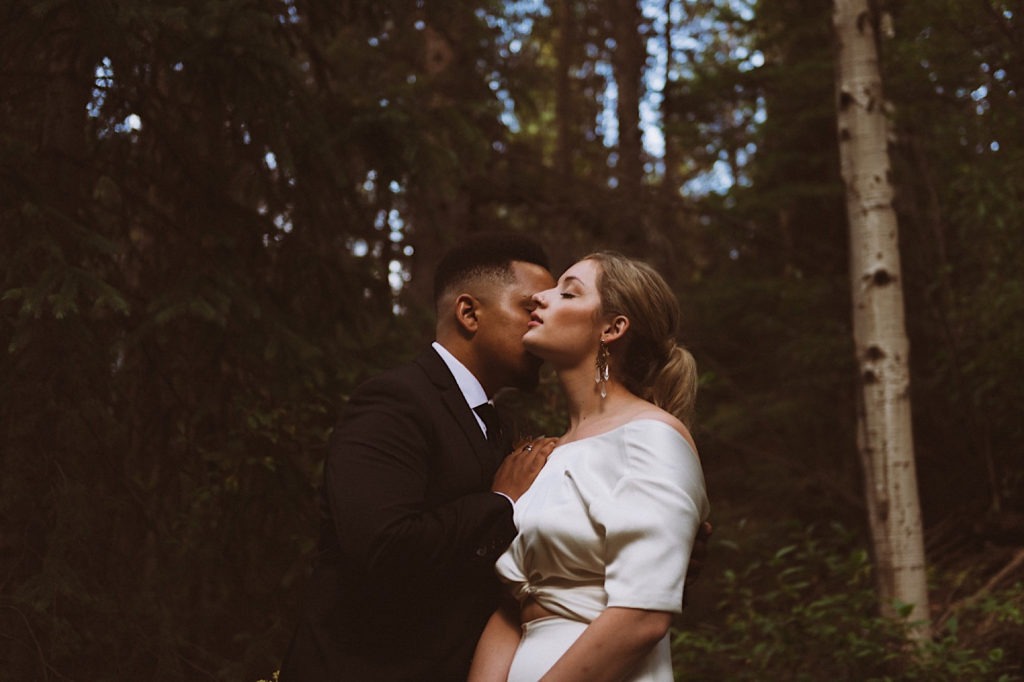 Bride and groom snuggling in the woods | Wedding portraits | Elopement portraits | Bride and groom elopement photos | Elopement wedding photos in Colorado | Colorado wedding photos | Colorado elopement photos | Elopement at Treehaus, Colorado | Treehaus Colorado | Colorado elopement | Treehaus elopement | Colorado elopement venue | Colorado mountain elopement venue | Unique elopement venue | Elopement venue in Colorado | Ashley Joyce Photography 2020