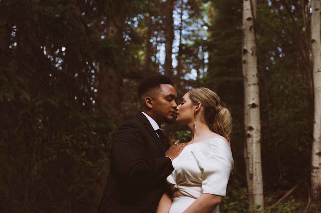Bride and groom snuggling nose to nose in the woods of Colorado | Wedding portraits | Elopement portraits | Bride and groom elopement photos | Elopement wedding photos in Colorado | Colorado wedding photos | Colorado elopement photos | Elopement at Treehaus, Colorado | Treehaus Colorado | Colorado elopement | Treehaus elopement | Colorado elopement venue | Colorado mountain elopement venue | Unique elopement venue | Elopement venue in Colorado | Ashley Joyce Photography 2020