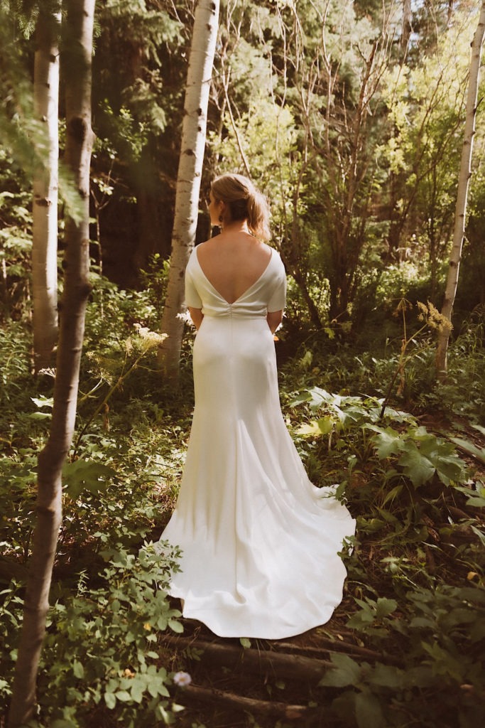 Bride standing in the woods of Colorado at Treehaus Colorado | Wedding portraits | Elopement portraits | Bride and groom elopement photos | Elopement wedding photos in Colorado | Colorado wedding photos | Colorado elopement photos | Elopement at Treehaus, Colorado | Treehaus Colorado | Colorado elopement | Treehaus elopement | Colorado elopement venue | Colorado mountain elopement venue | Unique elopement venue | Elopement venue in Colorado | Ashley Joyce Photography 2020