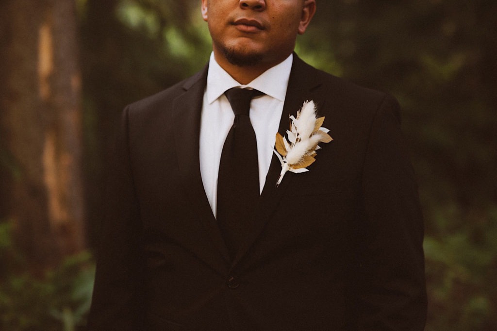 Boutonniere detail | Groom’s boutonniere | Groom standing in the forest in Colorado | Groom attire | Wedding portraits | Elopement portraits | Bride and groom elopement photos | Elopement wedding photos in Colorado | Colorado wedding photos | Colorado elopement photos | Elopement at Treehaus, Colorado | Treehaus Colorado | Colorado elopement | Treehaus elopement | Colorado elopement venue | Colorado mountain elopement venue | Unique elopement venue | Elopement venue in Colorado | Ashley Joyce Photography 2020