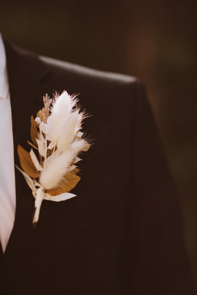 Boutonniere detail | Groom’s boutonniere | Groom standing in the forest in Colorado | Groom attire | Wedding portraits | Elopement portraits | Bride and groom elopement photos | Elopement wedding photos in Colorado | Colorado wedding photos | Colorado elopement photos | Elopement at Treehaus, Colorado | Treehaus Colorado | Colorado elopement | Treehaus elopement | Colorado elopement venue | Colorado mountain elopement venue | Unique elopement venue | Elopement venue in Colorado | Ashley Joyce Photography 2020