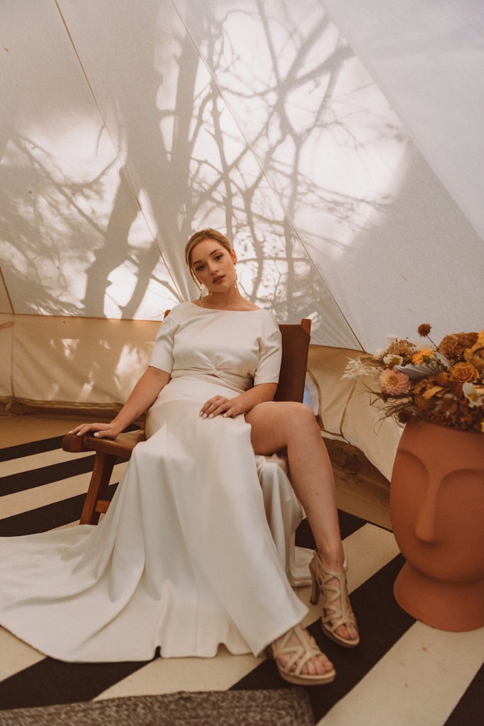 Bride sitting in bridal tent | Bride lounging in tent in Colorado | Colorado bridal prep | Wedding portraits | Elopement portraits | Bride and groom elopement photos | Elopement wedding photos in Colorado | Colorado wedding photos | Colorado elopement photos | Elopement at Treehaus, Colorado | Treehaus Colorado | Colorado elopement | Treehaus elopement | Colorado elopement venue | Colorado mountain elopement venue | Unique elopement venue | Elopement venue in Colorado | Ashley Joyce Photography 2020