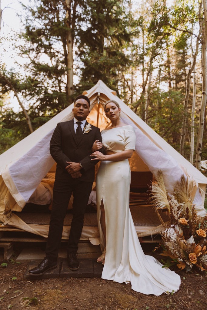 Bride and groom standing in front of wedding tent at Treehaus Colorado | Wedding portraits | Elopement portraits | Bride and groom elopement photos | Elopement wedding photos in Colorado | Colorado wedding photos | Colorado elopement photos | Elopement at Treehaus, Colorado | Treehaus Colorado | Colorado elopement | Treehaus elopement | Colorado elopement venue | Colorado mountain elopement venue | Unique elopement venue | Elopement venue in Colorado | Ashley Joyce Photography 2020