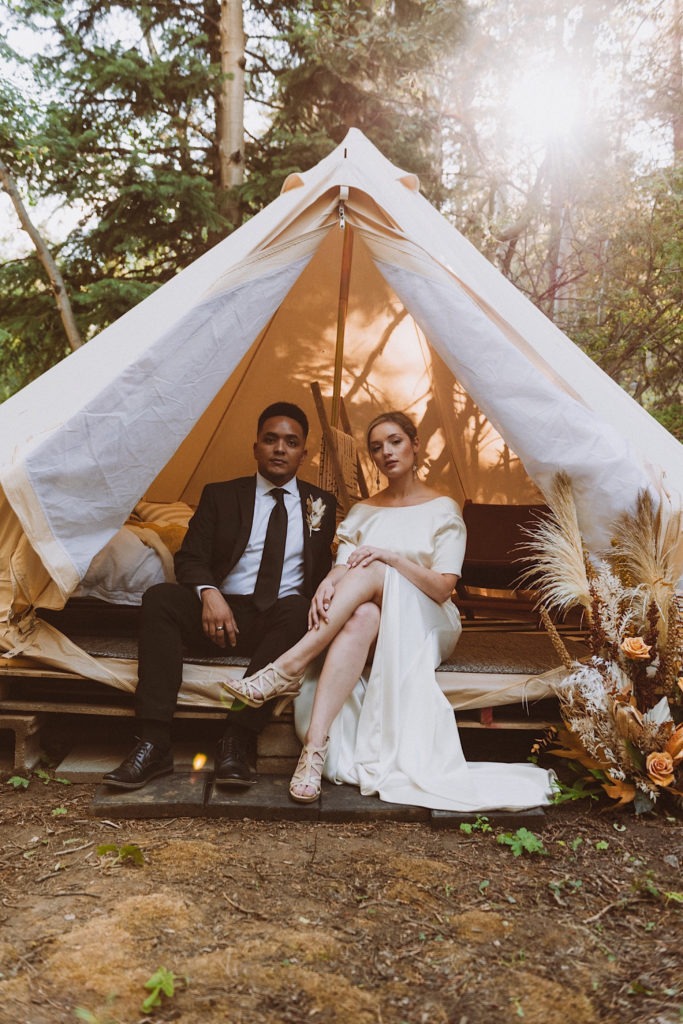 Bride and groom sitting in wedding tent at Treehaus Colorado | Wedding portraits | Elopement portraits | Bride and groom elopement photos | Elopement wedding photos in Colorado | Colorado wedding photos | Colorado elopement photos | Elopement at Treehaus, Colorado | Treehaus Colorado | Colorado elopement | Treehaus elopement | Colorado elopement venue | Colorado mountain elopement venue | Unique elopement venue | Elopement venue in Colorado | Ashley Joyce Photography 2020