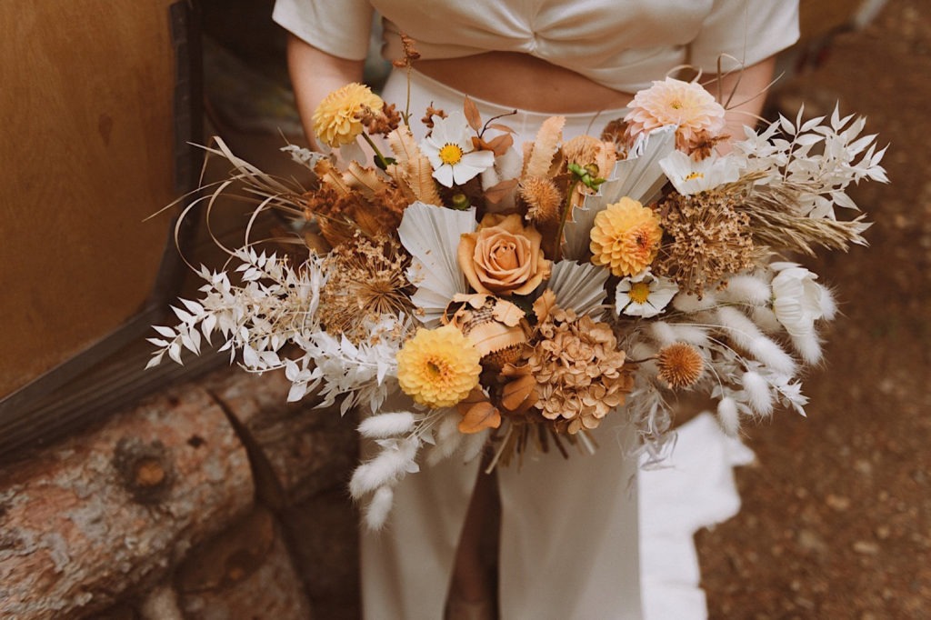 Closeup of bridal bouquet | Bride holding wedding bouquet in Colorado at Treehaus Colorado | Treehaus CO | Wedding portraits | Elopement portraits | Bride and groom elopement photos | Elopement wedding photos in Colorado | Colorado wedding photos | Colorado elopement photos | Elopement at Treehaus, Colorado | Treehaus Colorado | Colorado elopement | Treehaus elopement | Colorado elopement venue | Colorado mountain elopement venue | Unique elopement venue | Elopement venue in Colorado | Ashley Joyce Photography 2020