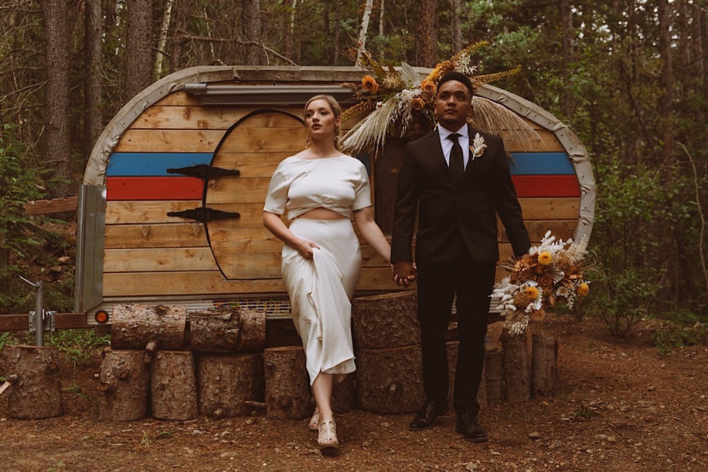 Bride and groom standing in front of a teardrop trailer at Treehaus CO | Treehaus Colorado | Wedding portraits | Elopement portraits | Bride and groom elopement photos | Elopement wedding photos in Colorado | Colorado wedding photos | Colorado elopement photos | Elopement at Treehaus, Colorado | Treehaus Colorado | Colorado elopement | Treehaus elopement | Colorado elopement venue | Colorado mountain elopement venue | Unique elopement venue | Elopement venue in Colorado | Ashley Joyce Photography 2020