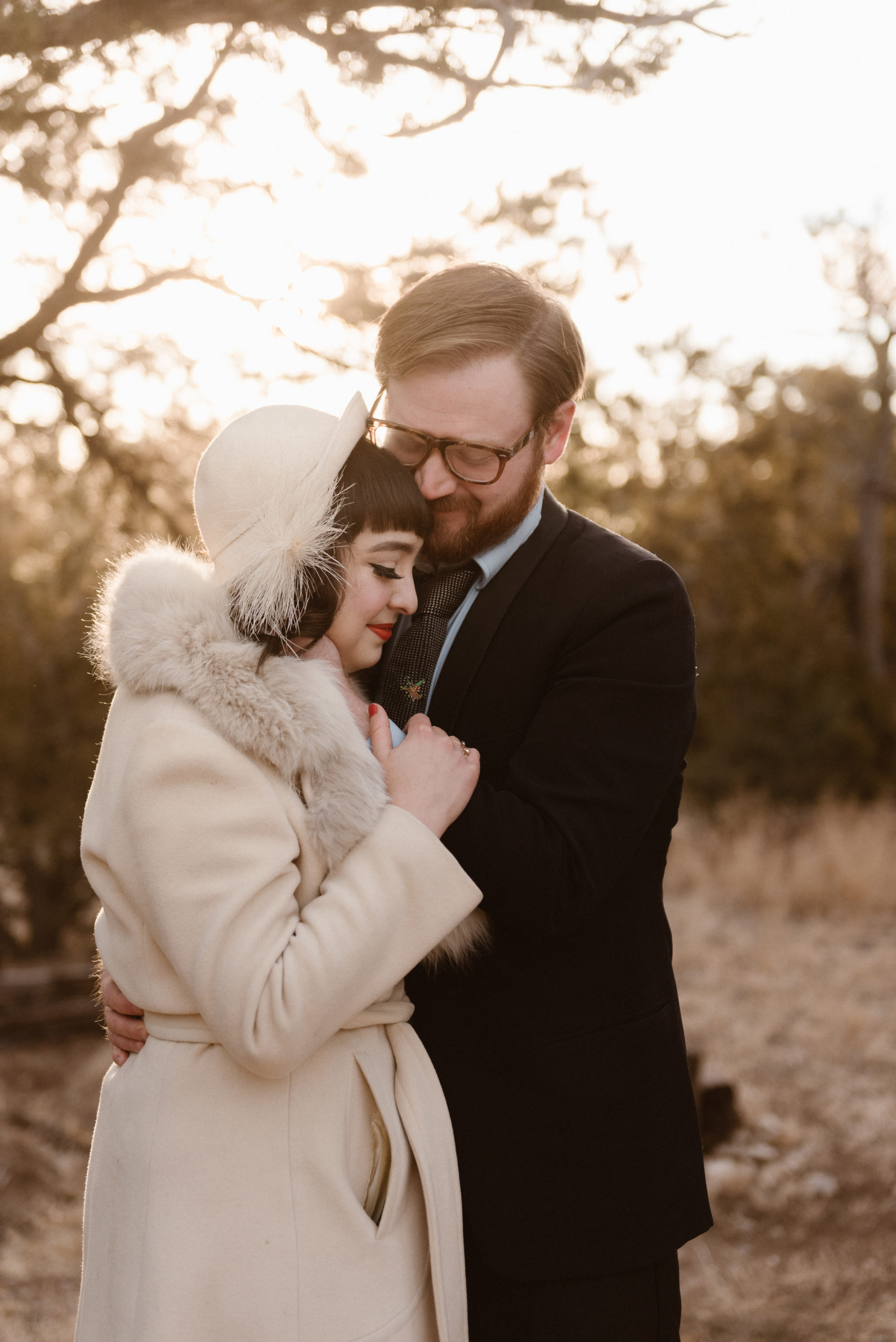 A New Mexico elopement couple stands together as they wrap their arms around each other and snuggle while they close their eyes. Photo by Denver elopement photographer, Colorado elopement photographer, Ashley Joyce Photography.