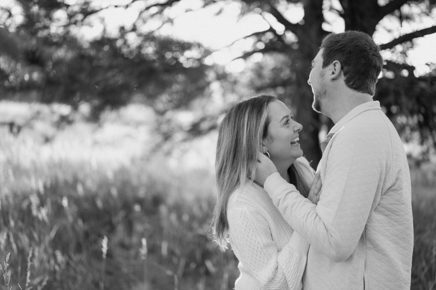 A black and white photos of an engaged couple embracing each other in Elk Meadow Park in Evergreen, Colorado for their Colorado engagement photos, taken by Colorado wedding photographer Ashley Joyce Photography.