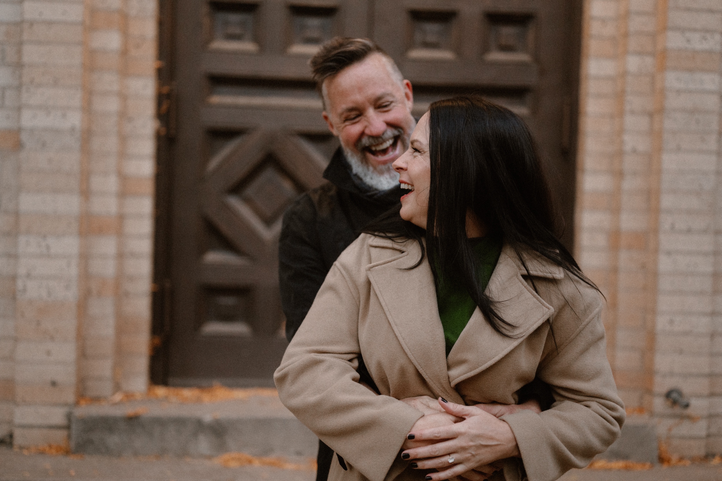 A color photo of an engaged couple laughing together while they hold one another for their engagement session in Durango, Colorado. Photo by Ashley Joyce.