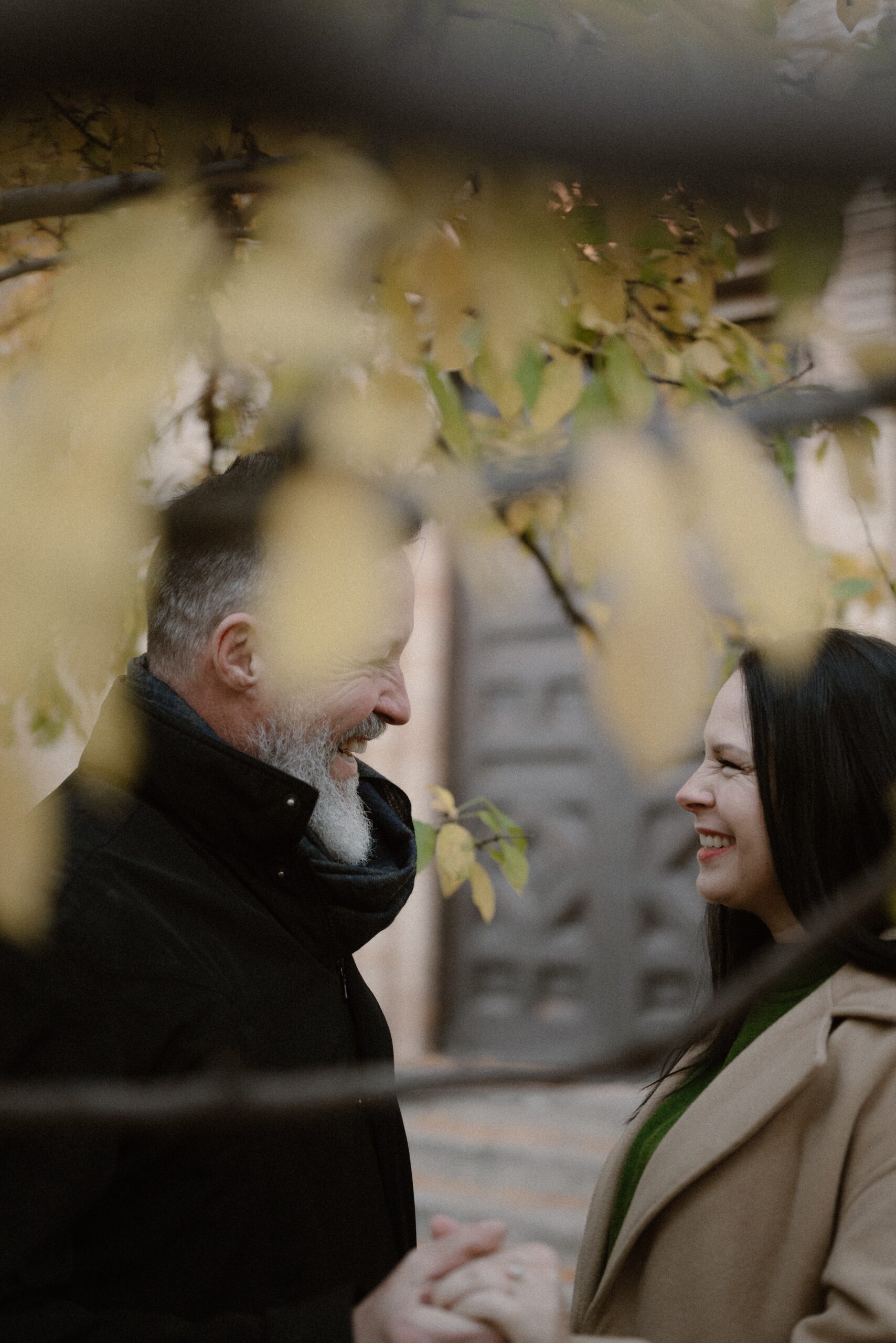 A color photo of an engaged couple laughing at one another while they pose for their Colorado engagement session in Durango, Colorado.