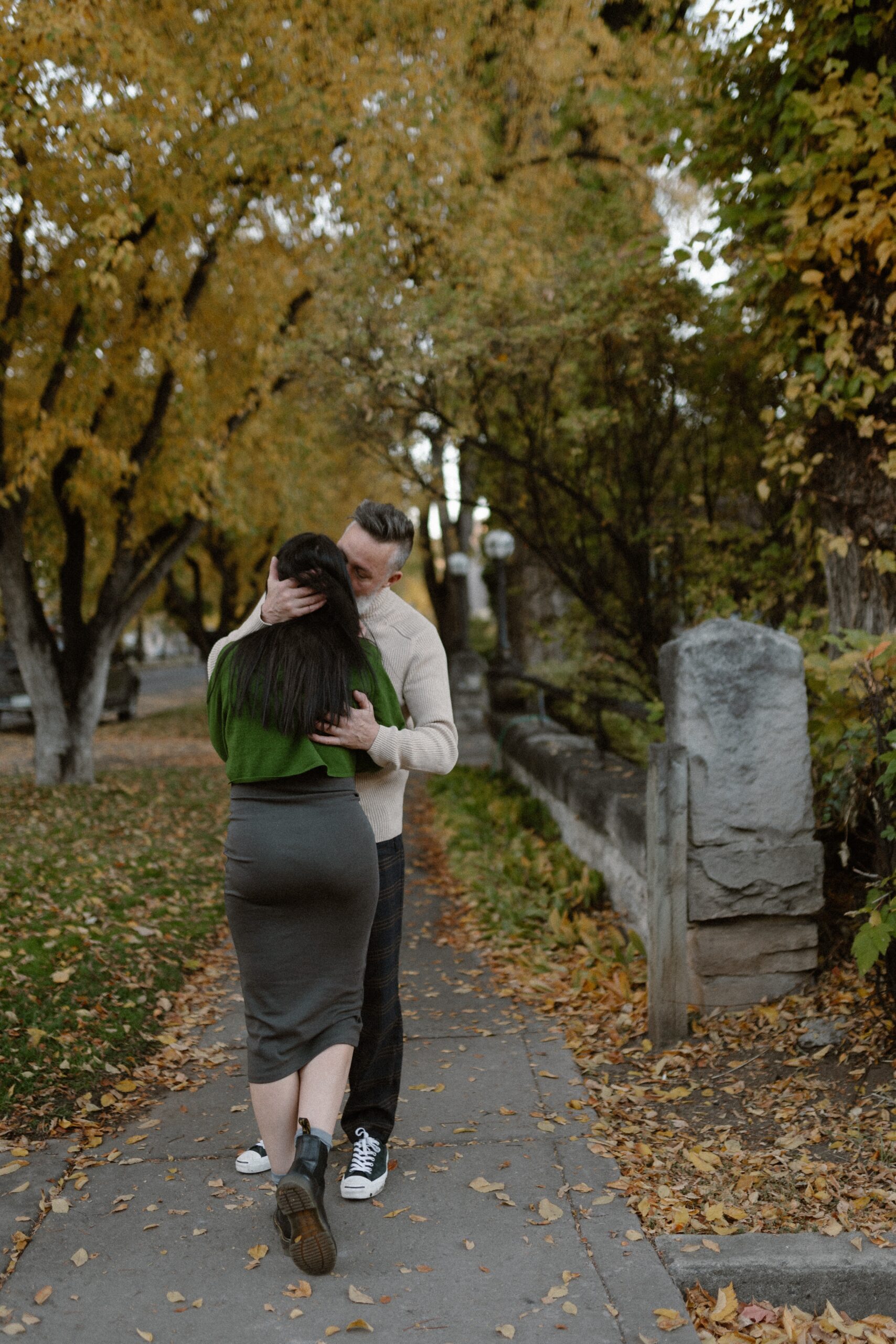 A photo of a man intimately embracing his fiance in Downtown Durango, Colorado for their engagement session. Photo by Ashley Joyce