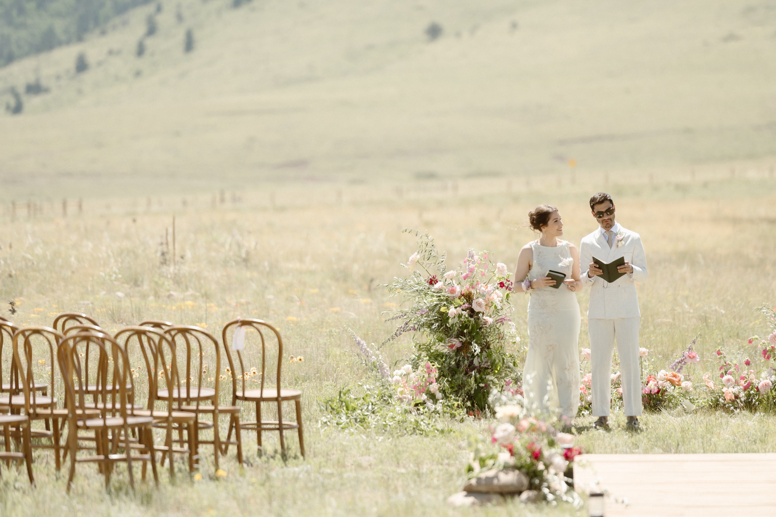 Two officiants standing at the ceremony space for a Three Peaks Ranch wedding. Photo by Colorado wedding photographer Ashley Joyce.