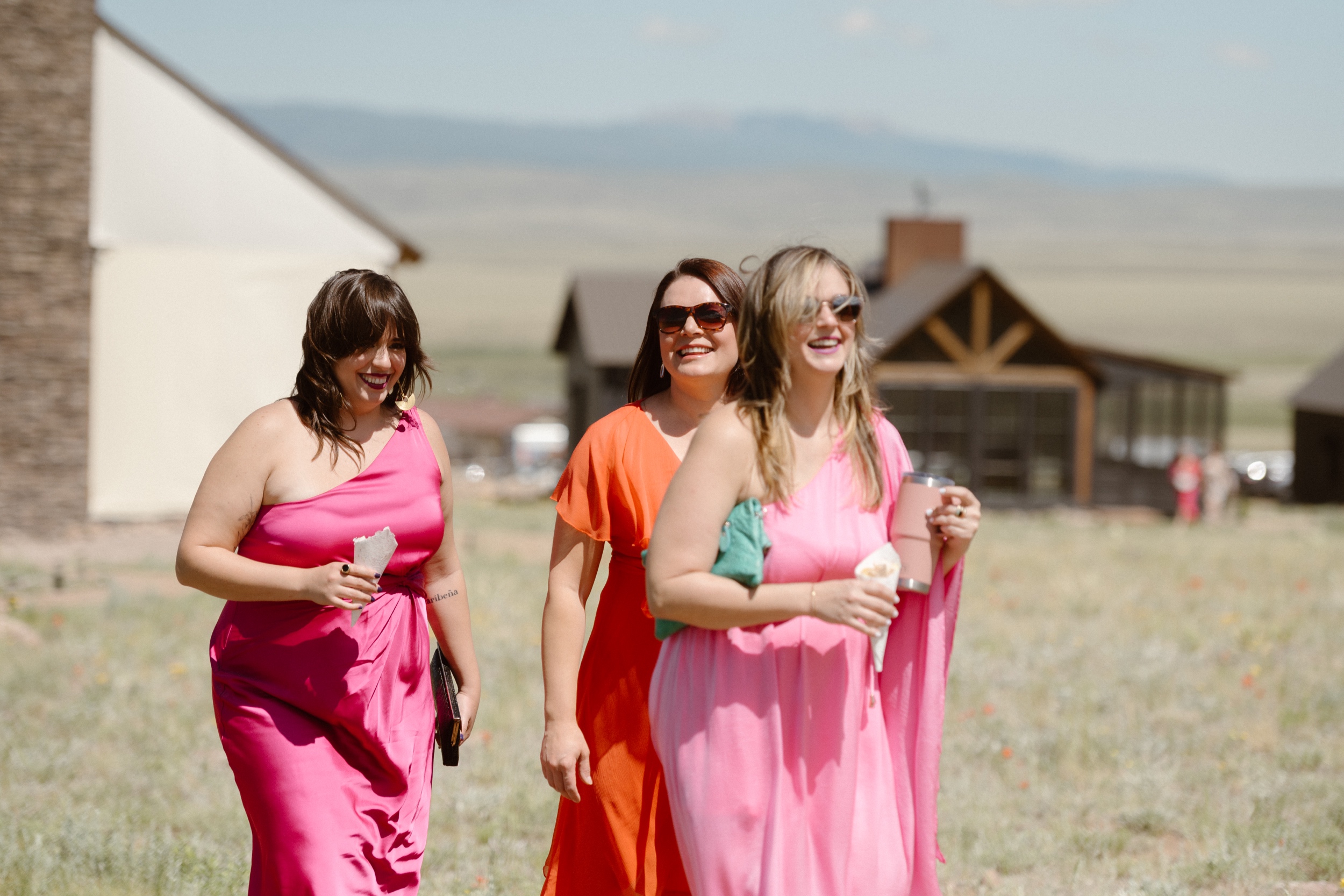 Wedding guests walking along a wooden path to find their seats for the wedding ceremony at Three Peaks Ranch. Photo by Colorado wedding photographer Ashley Joyce.