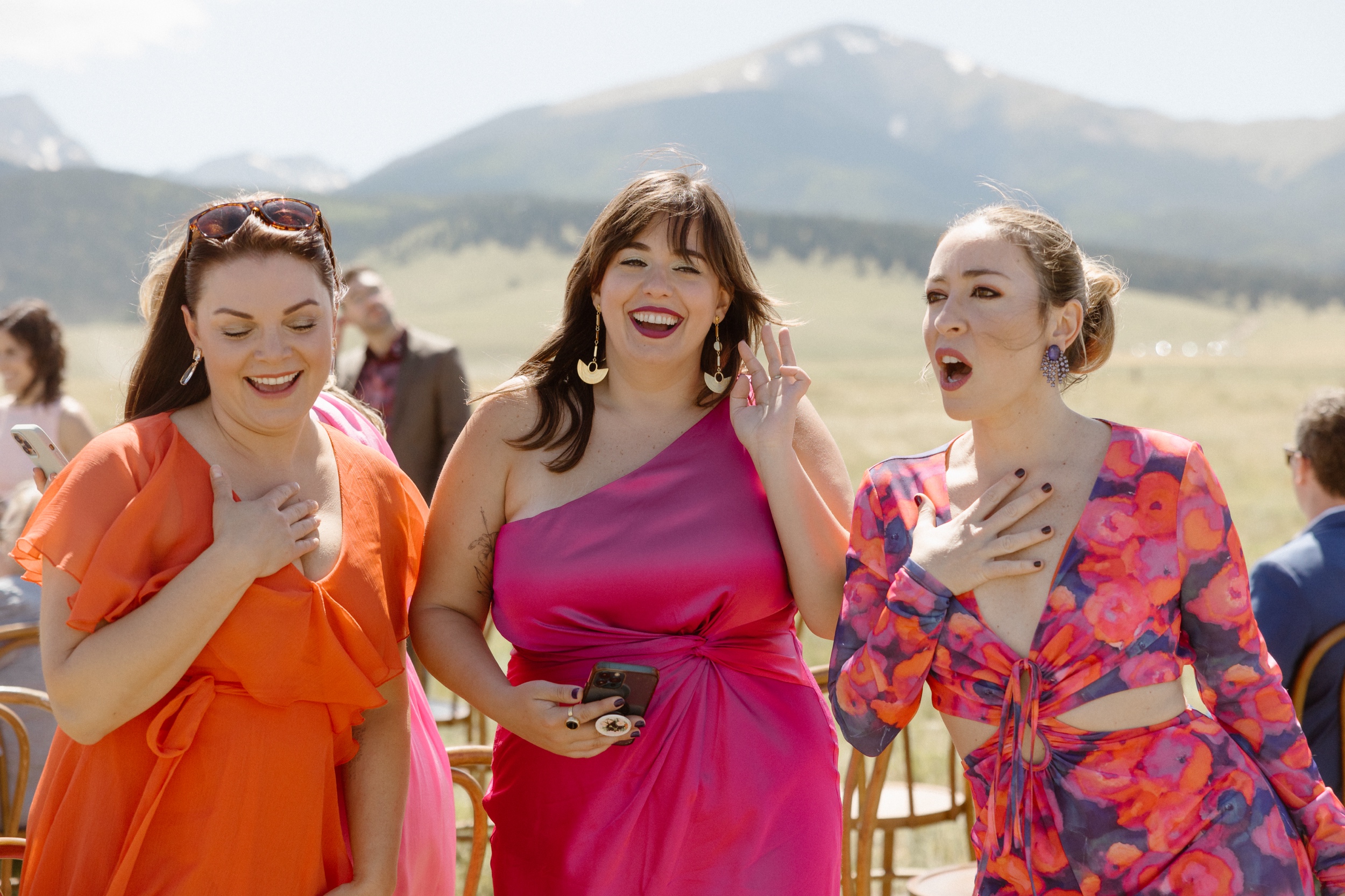 Three wedding guests smiling and having fun at the wedding at Three Peaks Ranch. Photo by Colorado wedding photographer Ashley Joyce.