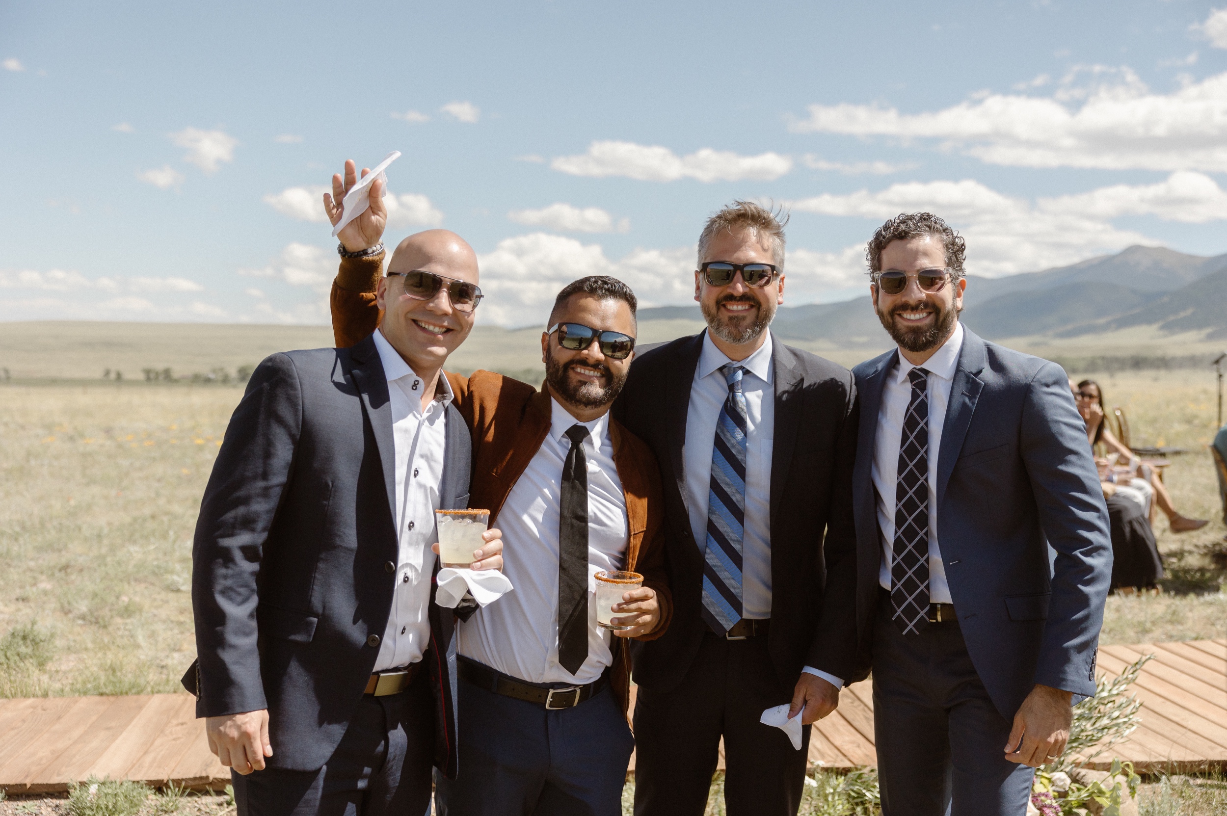 A portrait of four men posing for a photo at the Three Peaks Ranch wedding for Jessica and Bernard. Photo by Colorado wedding photographer, Ashley Joyce