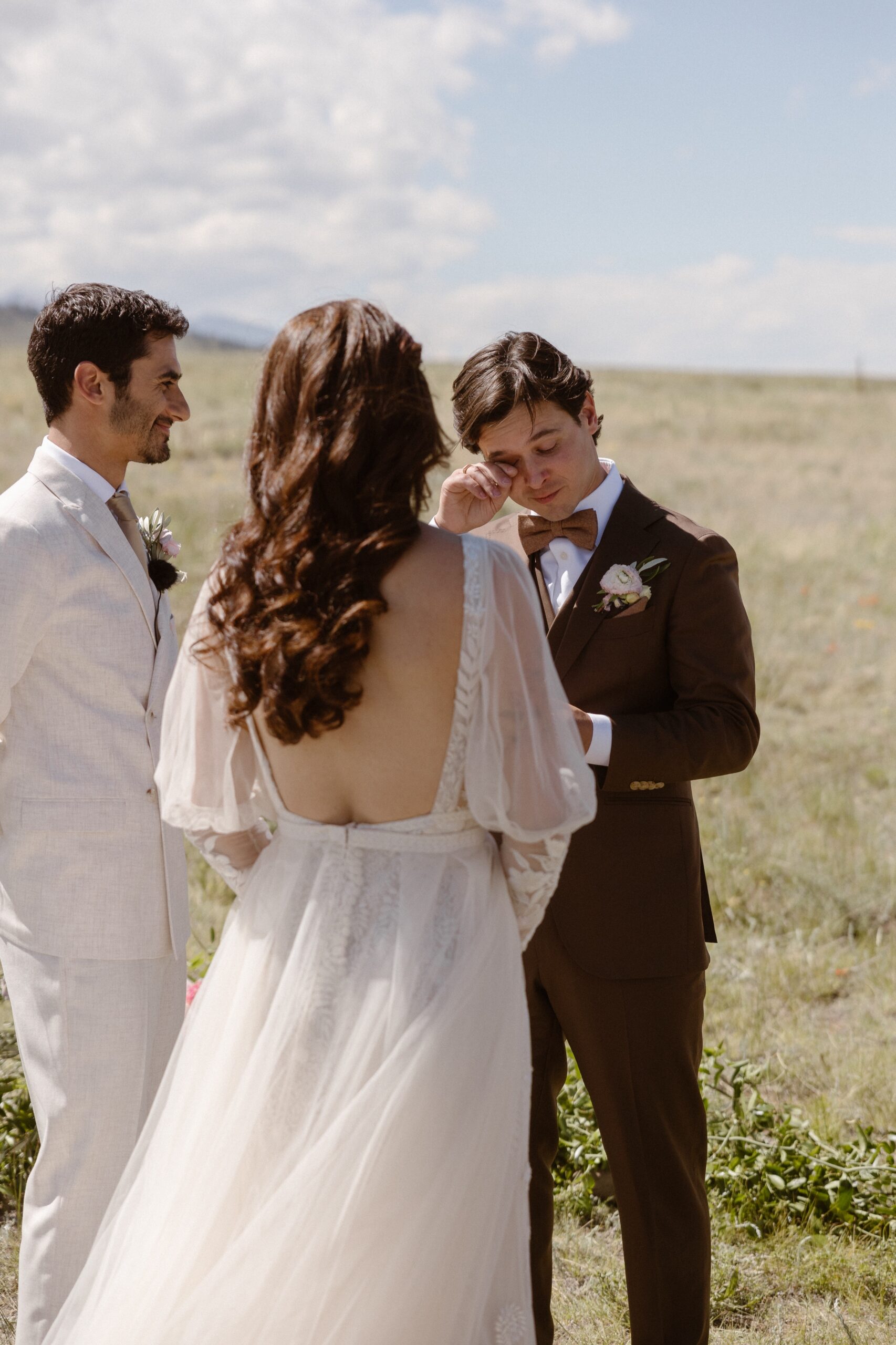 A photo of a groom crying while he says his wedding vows at Three Peaks Ranch. Photo by Colorado wedding photographer Ashley Joyce.