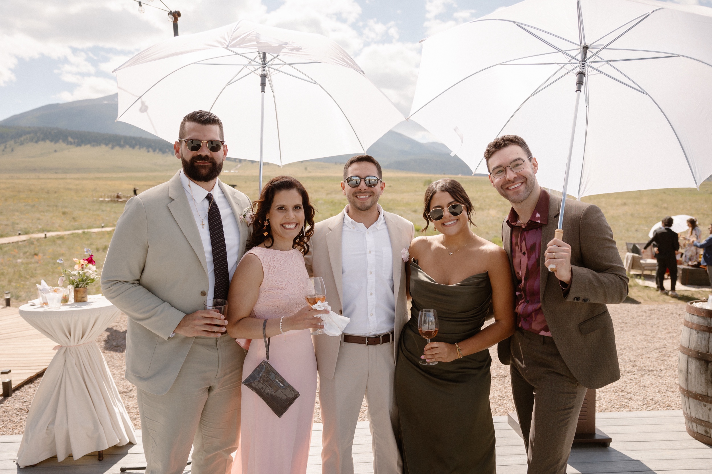 A portrait of five different wedding guests and family members posing for a photo at Three Peaks Ranch. Photo by Colorado wedding photographer Ashley Joyce.