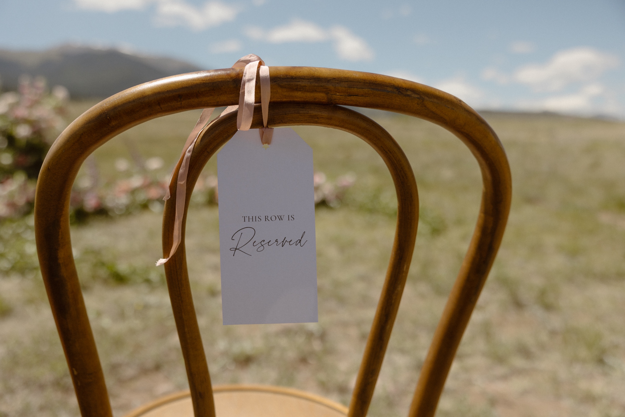 A photo of a Reserved tag hanging on a wooden chair outside at Three Peaks Ranch. Photo by Ashley Joyce.