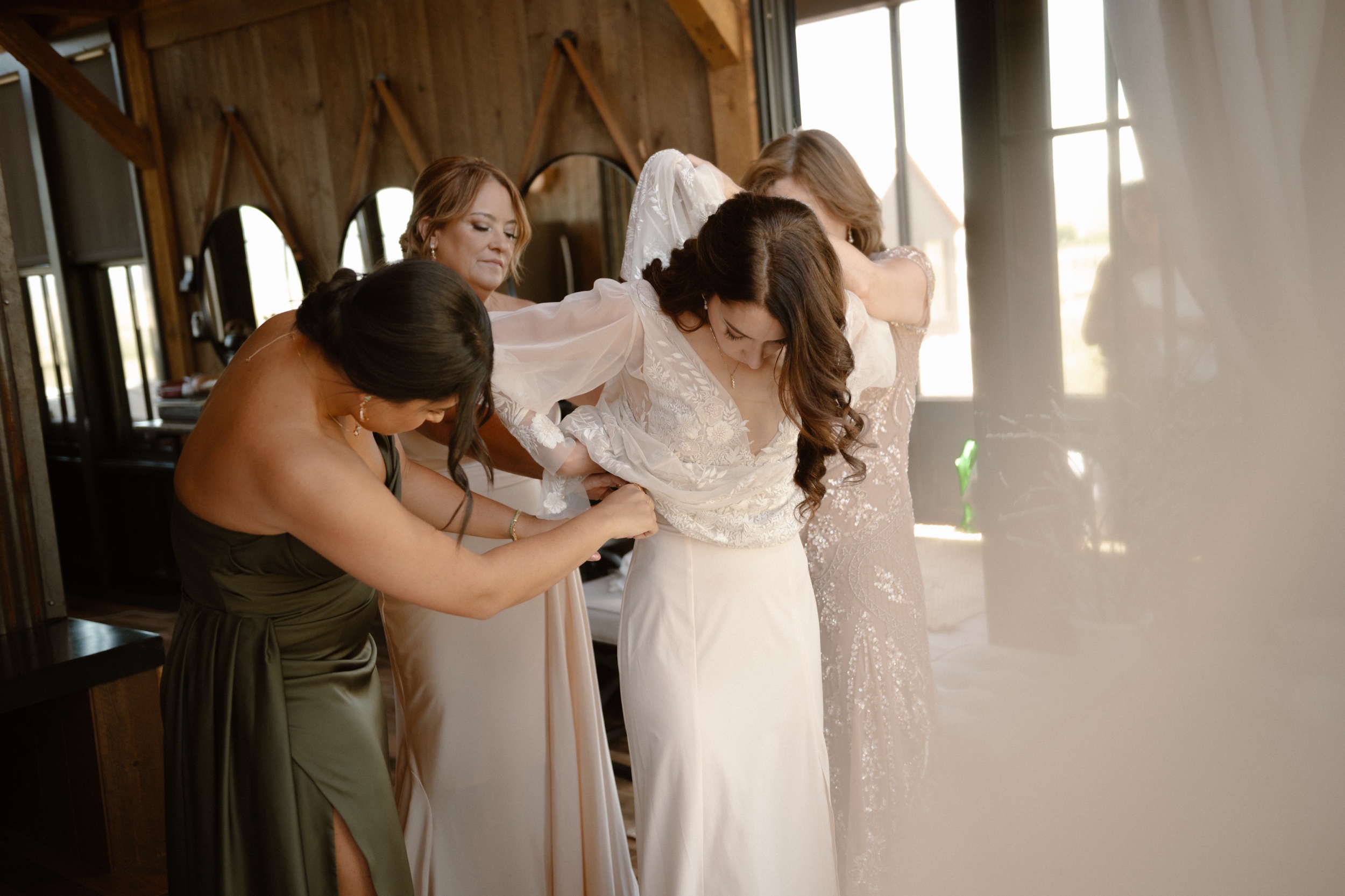 A bride getting dressed for her Three Peaks Ranch wedding. Photo by Ashley Joyce.
