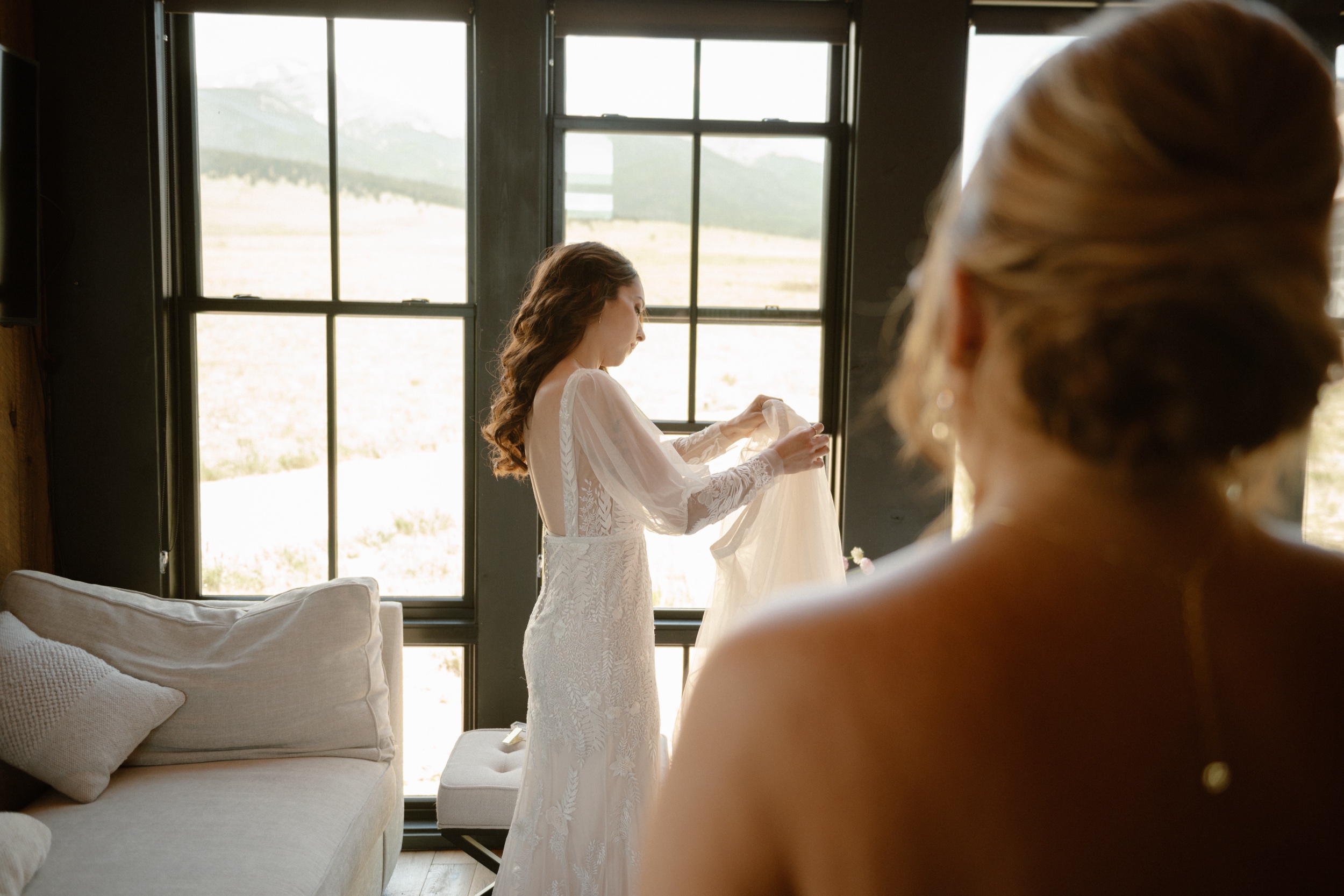 A bride putting on her wedding skirt at Three Peaks Ranch. Photo by Ashley Joyce.