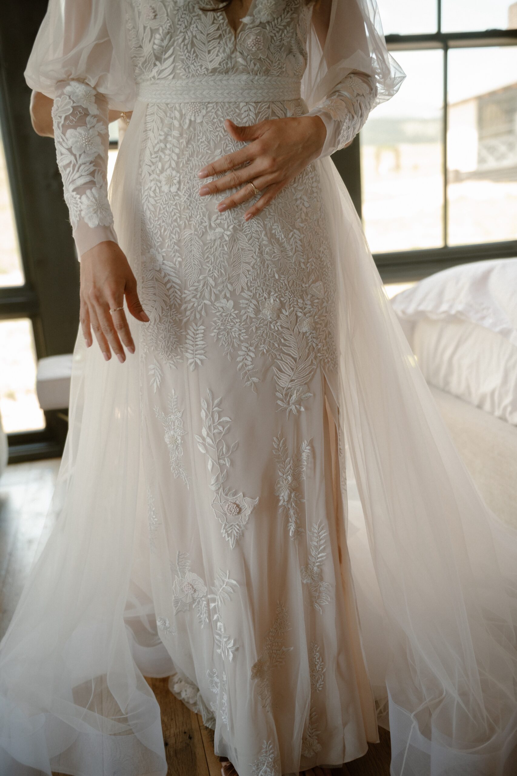 A photo of a bride's torso as she gets in her wedding dress. Photo by Ashley Joyce.