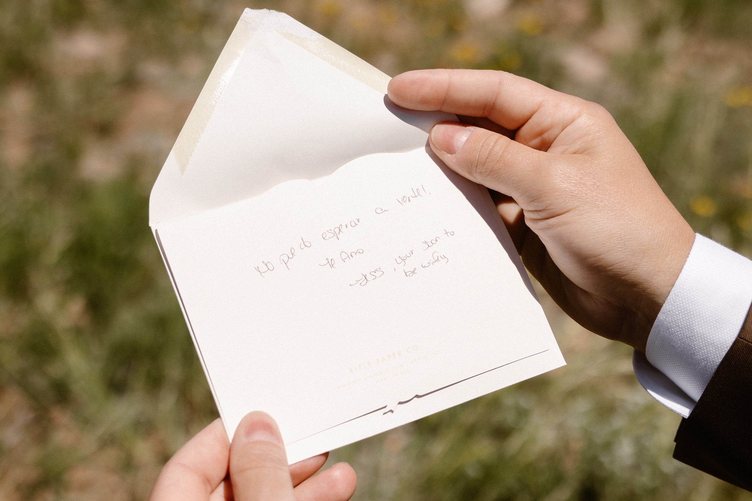 A photo of a groom opening up a secret letter from his future wife. Photo by Colorado wedding photographer Ashley Joyce.