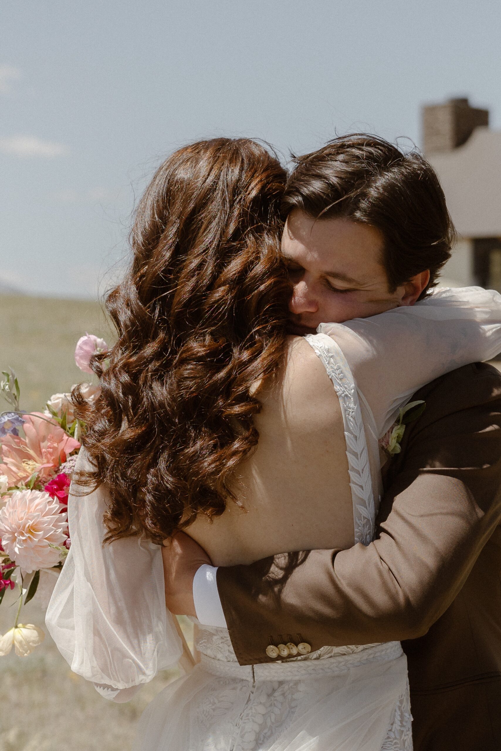 A bride and groom hug each other at Three Peaks Ranch. Photo by Colorado wedding photographer Ashley Joyce.