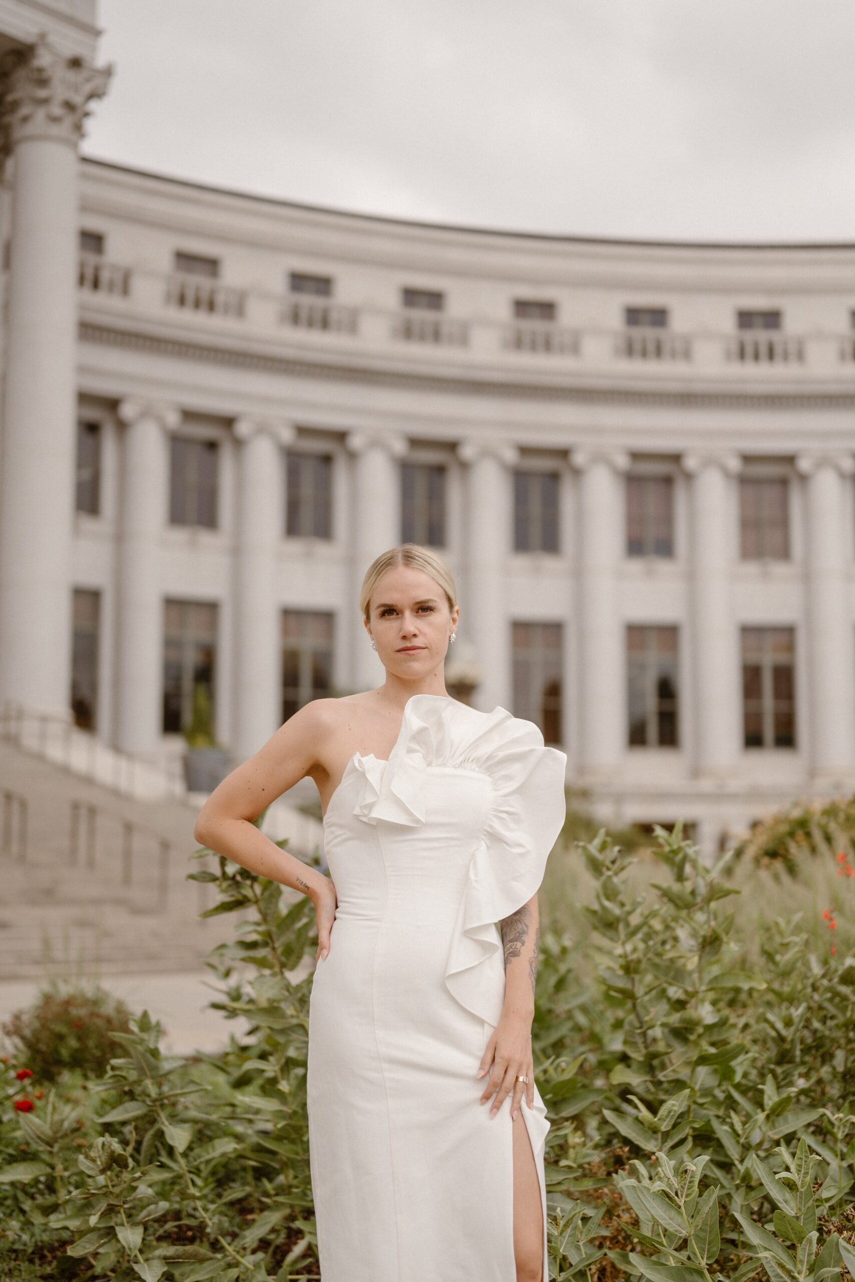 A bride poses for her wedding portraits in front of the Denver courthouse. Photo by Colorado wedding photographer Ashley Joyce.