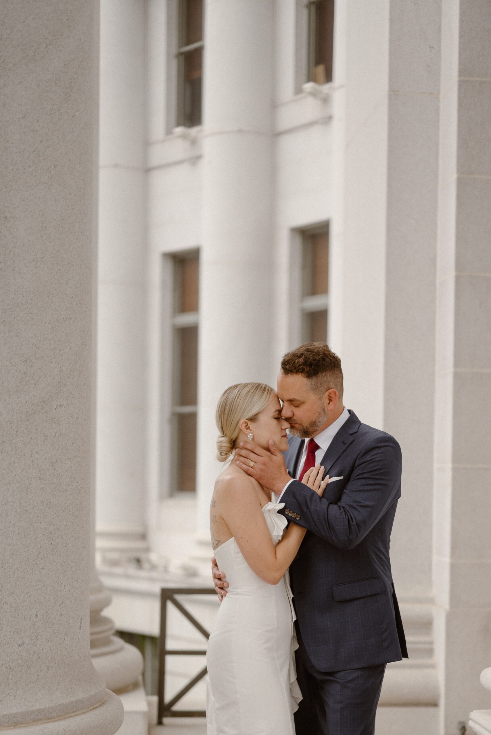 A bride and groom pose for their Denver courthouse elopement. Photo by Colorado wedding photographer Ashley Joyce.