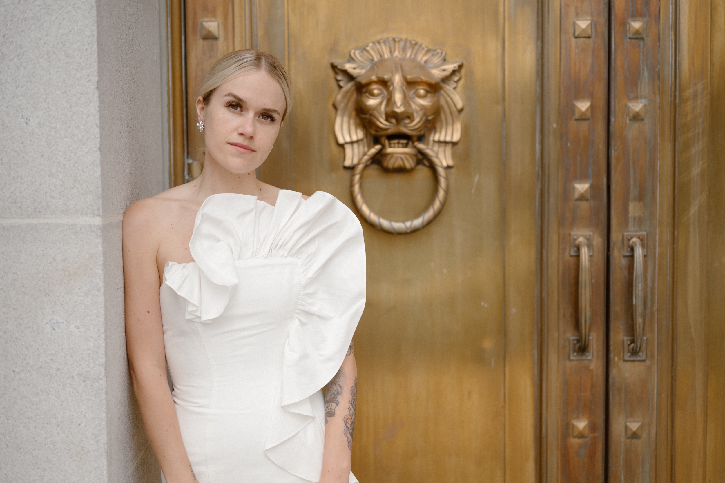 A bride poses in front of a golden door for her wedding portraits. Photo by Colorado wedding photographer Ashley Joyce.