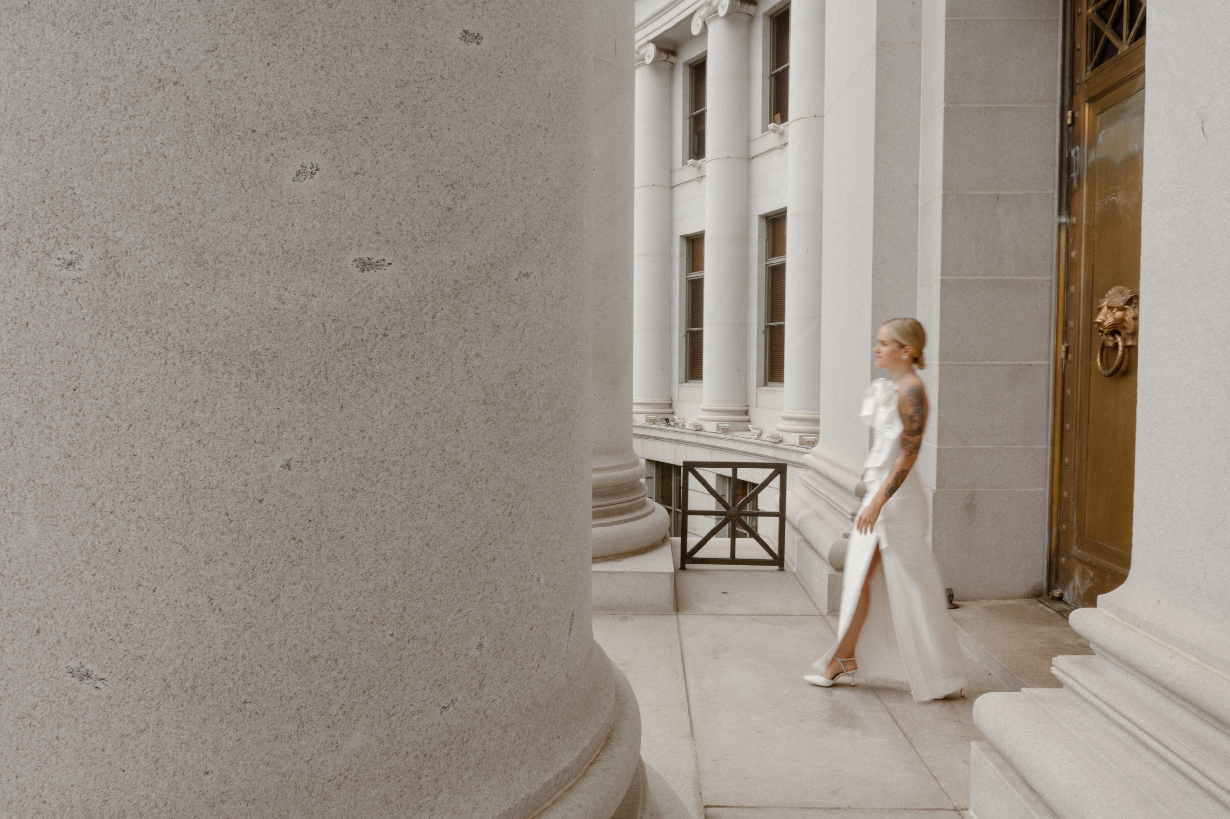 A blurry photo of a bride walking towards her husband at the Denver Courthouse. Photo by Colorado wedding photographer Ashley Joyce.