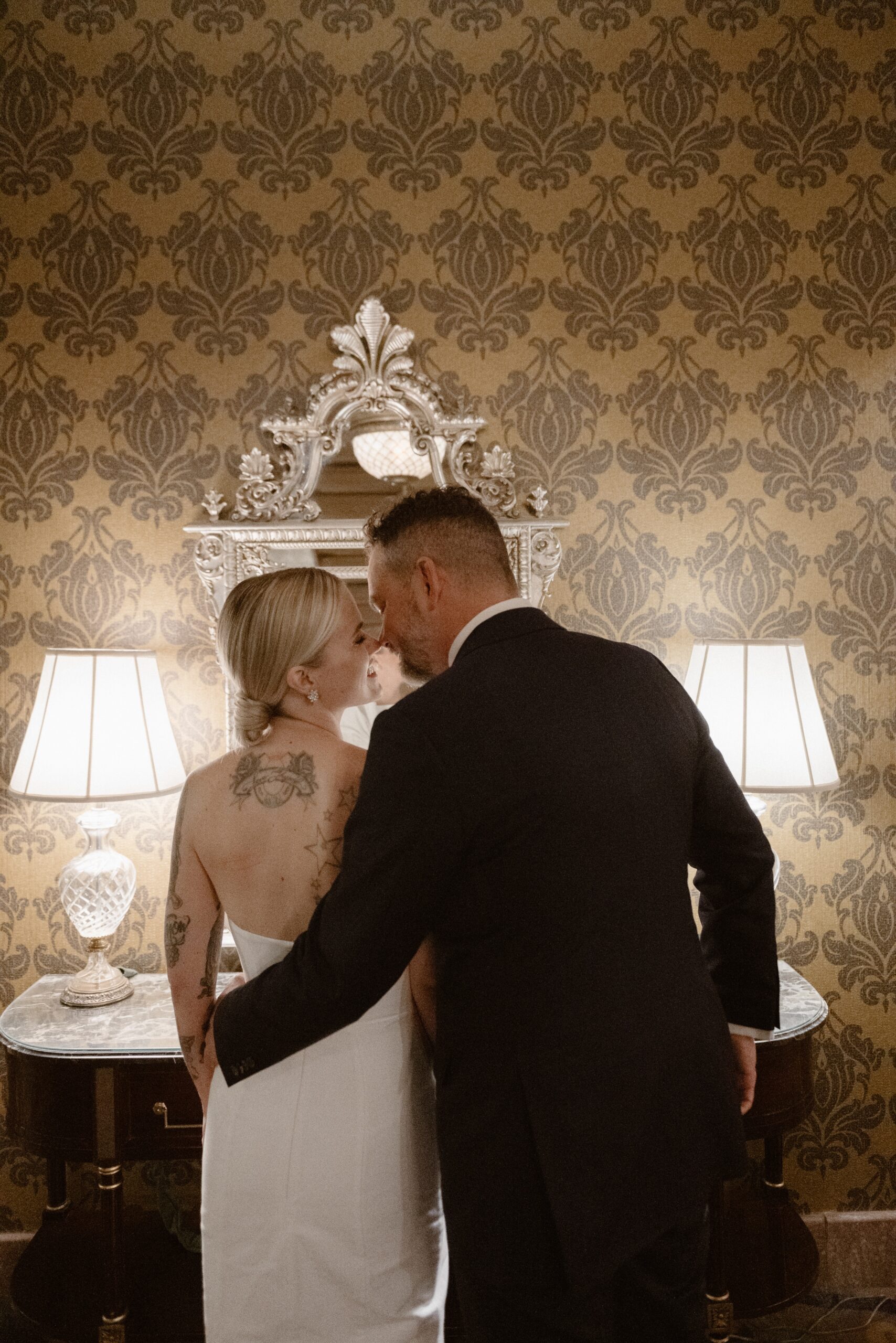 A bride and groom pose for their wedding portraits at the Brown Palace in Denver, Colorado. Photo by Colorado wedding photographer Ashley Joyce.