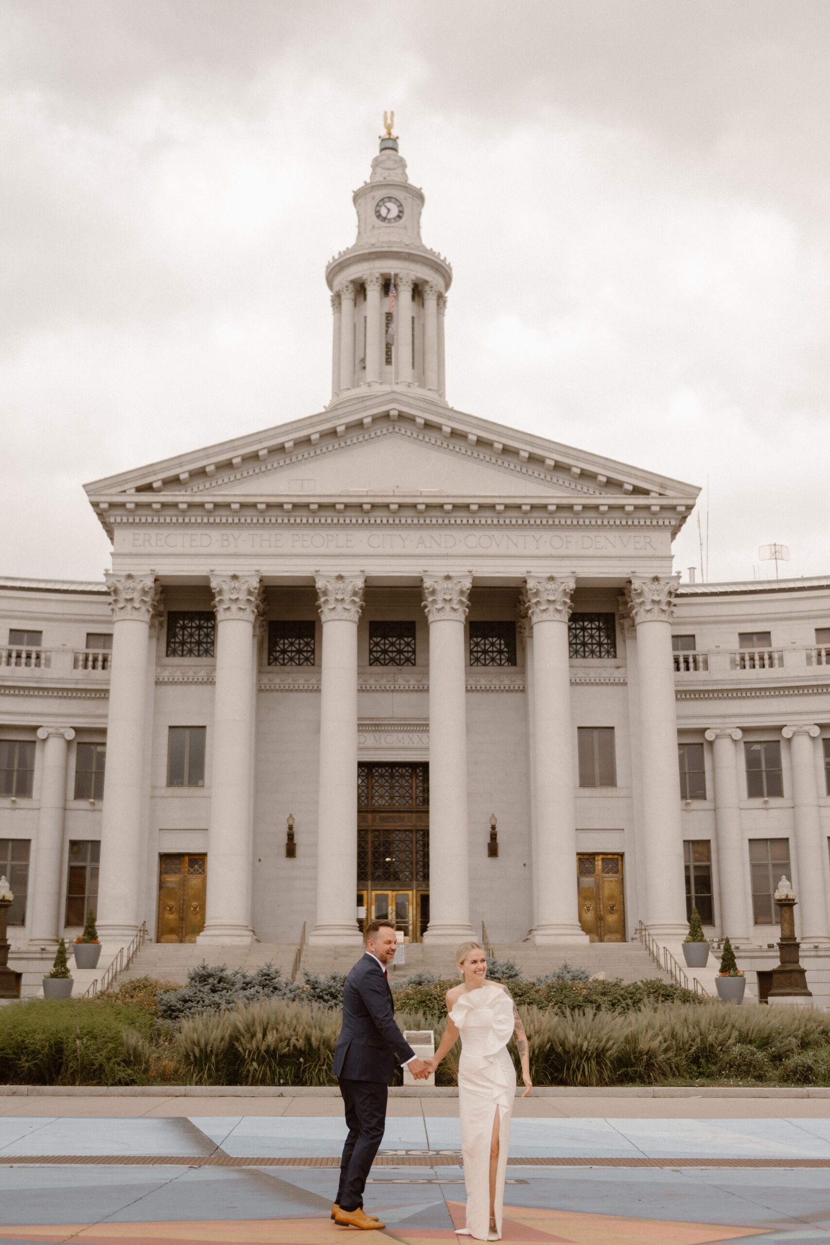 A bride and groom pose for their Denver courthouse wedding. Photo by Colorado wedding photographer Ashley Joyce.