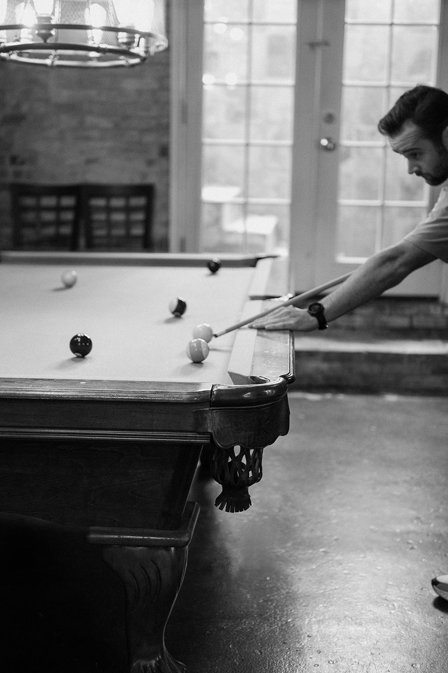 A groomsman playing pool at The Manor House